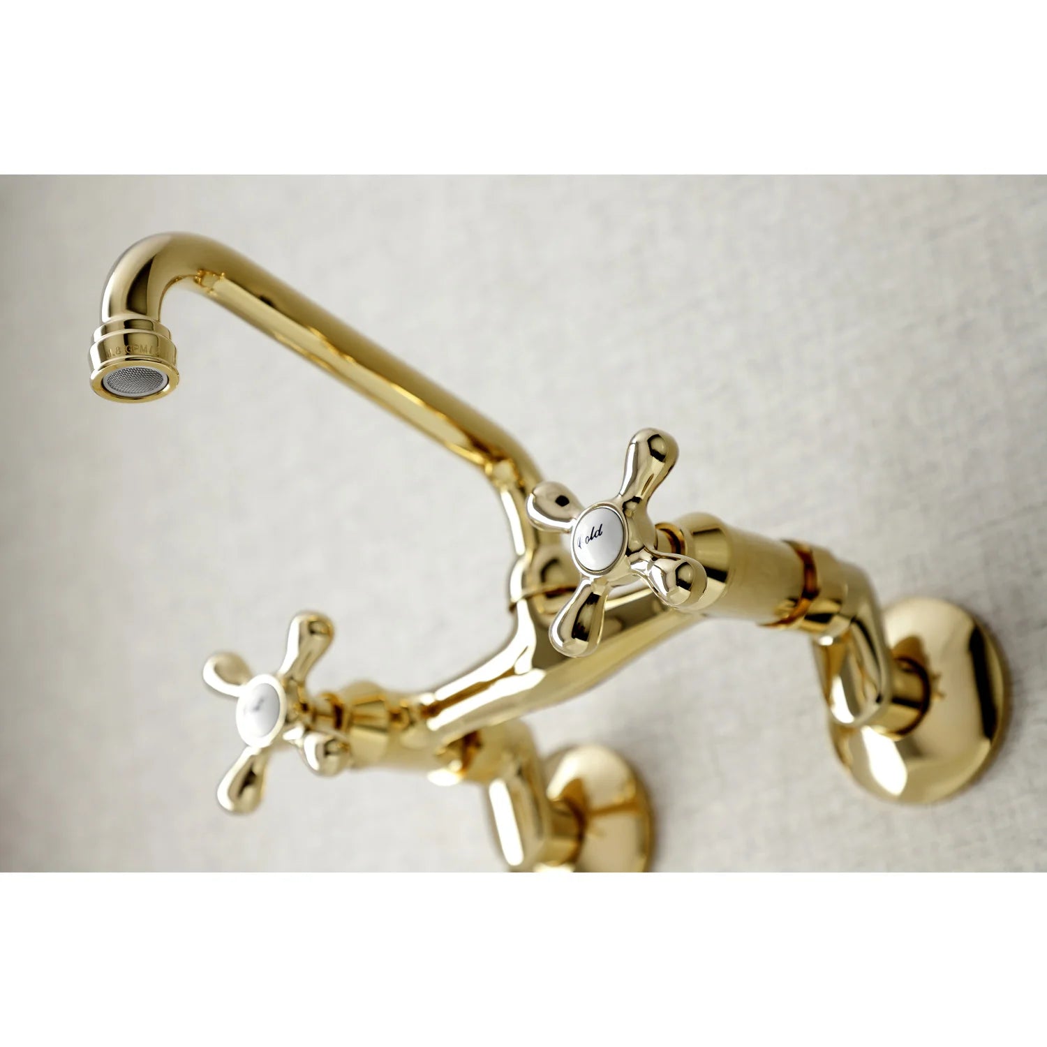 Polished brass wall-mount bridge faucet with curved gooseneck spout and cross handles