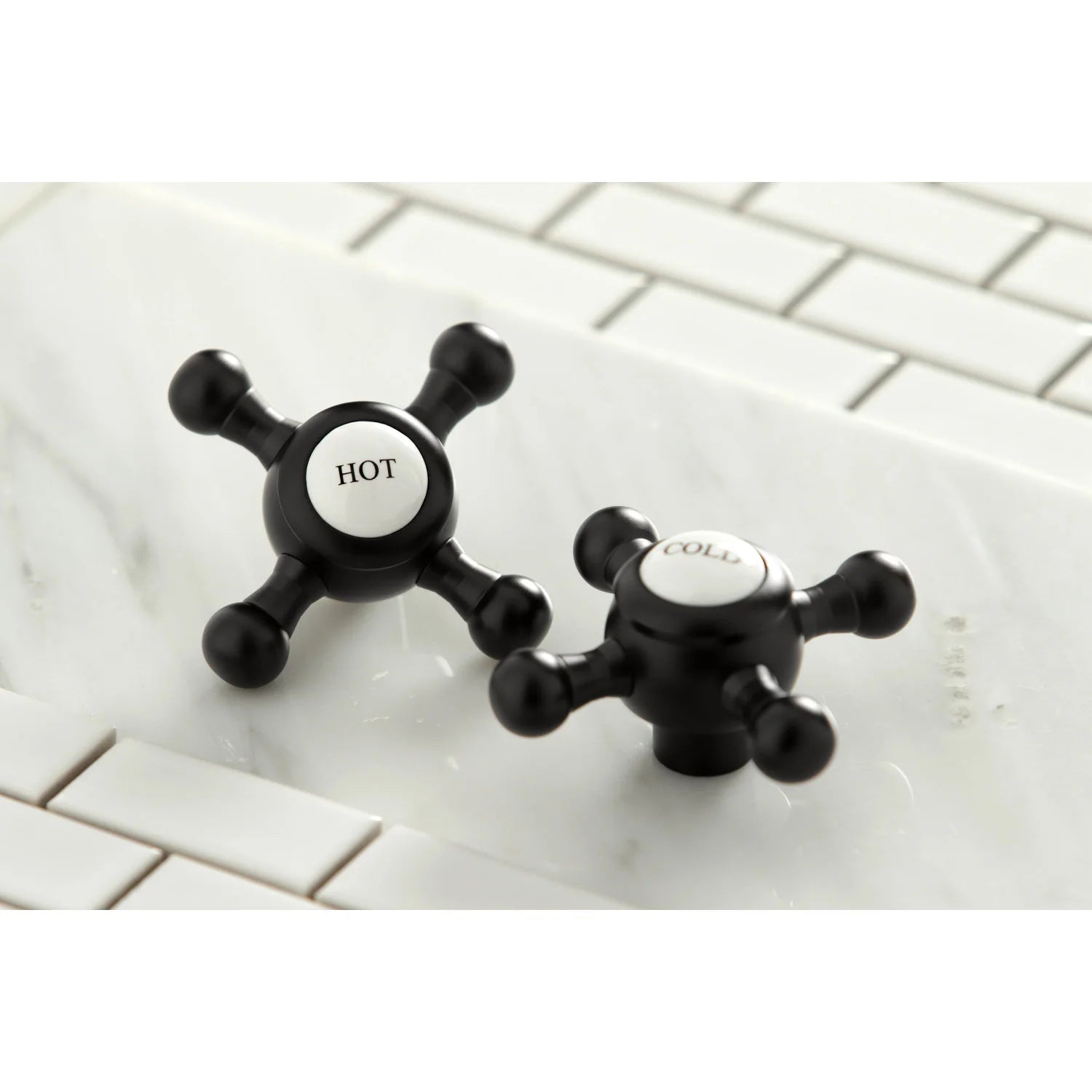 Matte black faucet handles with HOT and COLD caps on widespread centers