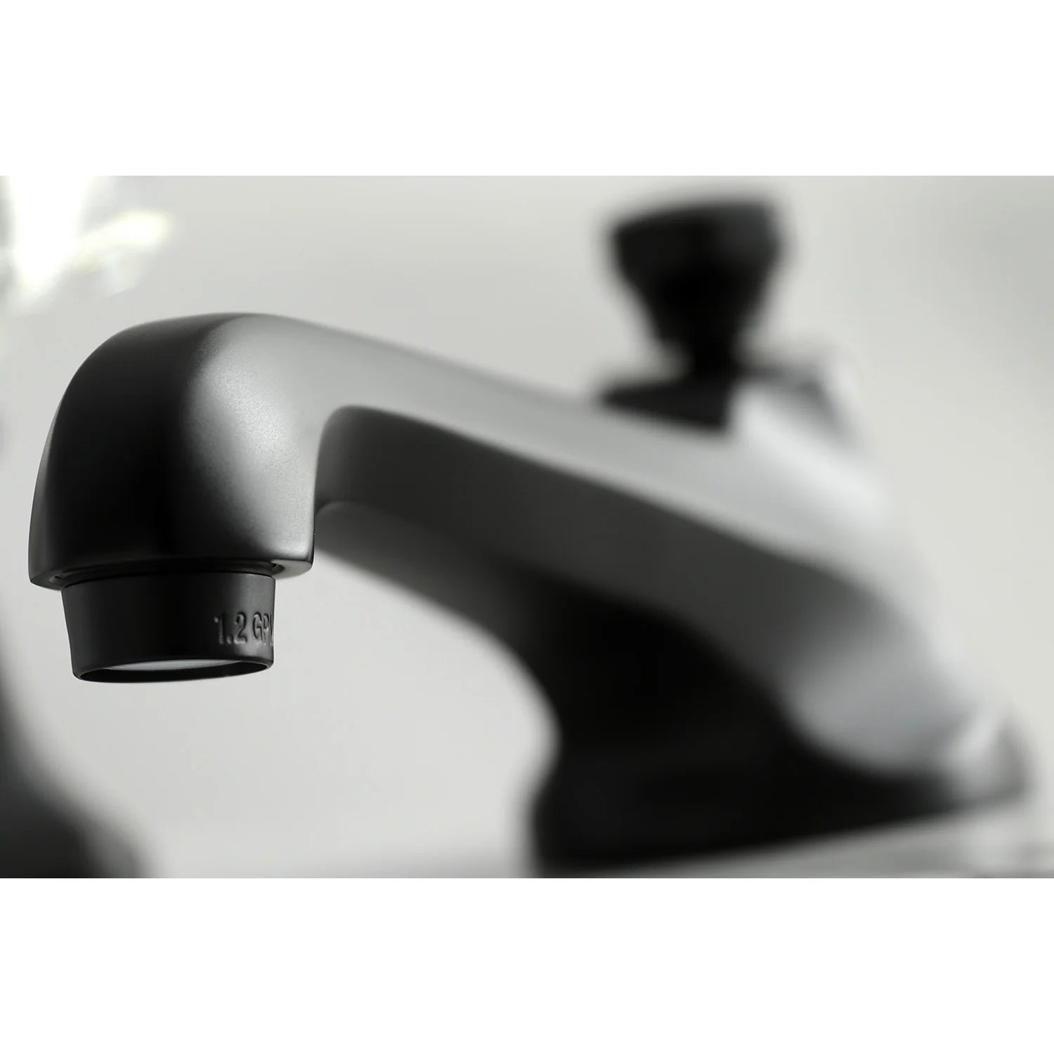 Matte black faucet spout close-up with single-piece aerator and base trim