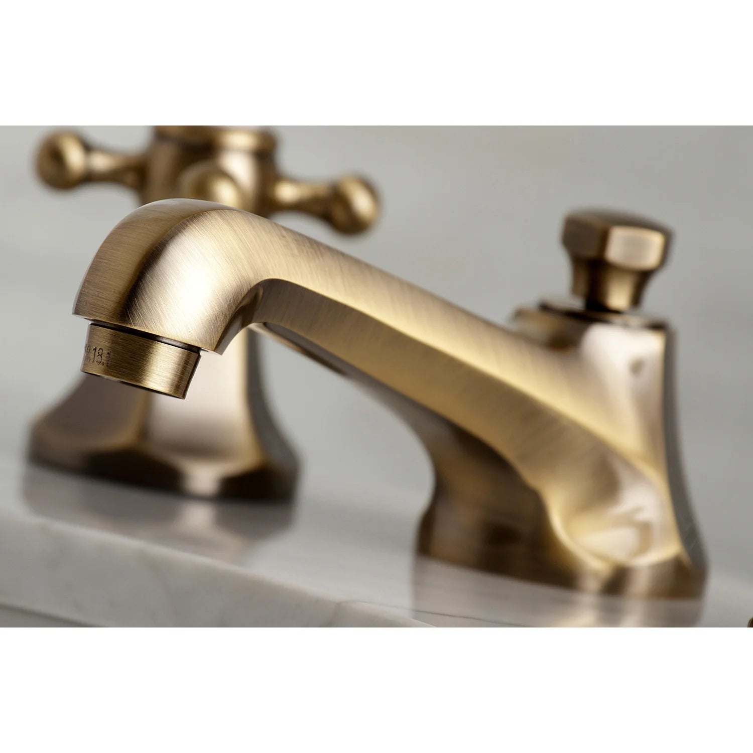 Antique brass bathroom faucet spout with two lever handles and pop-up drain detail