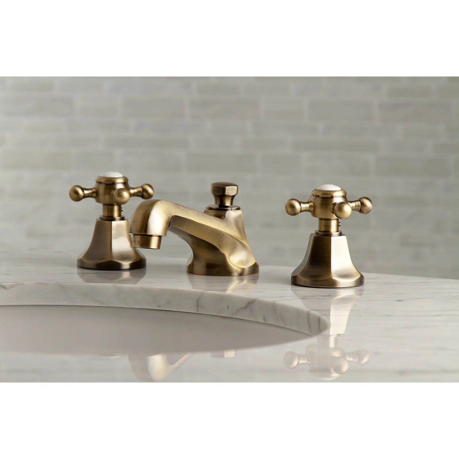 Antique brass widespread bathroom faucet set with two handles and pop-up drain on countertop