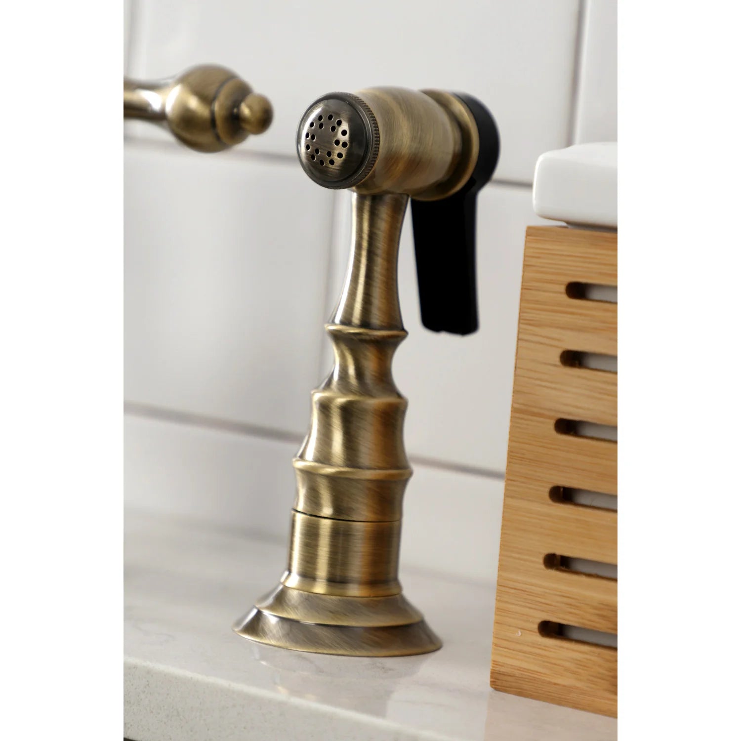 Close-up of antique brass side sprayer with spray head and pull-down handle