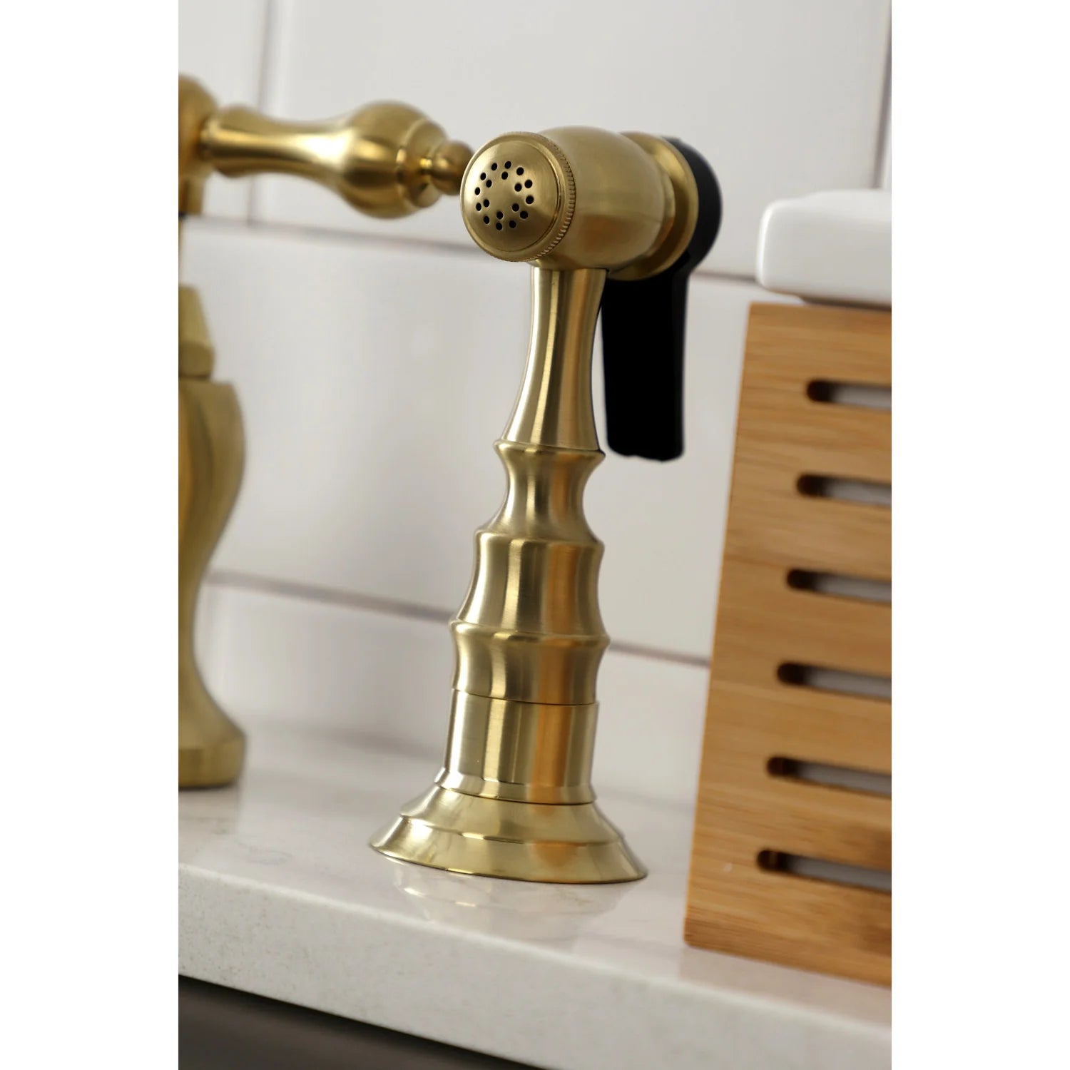 Brushed brass side sprayer head and nozzle mounted on kitchen faucet body