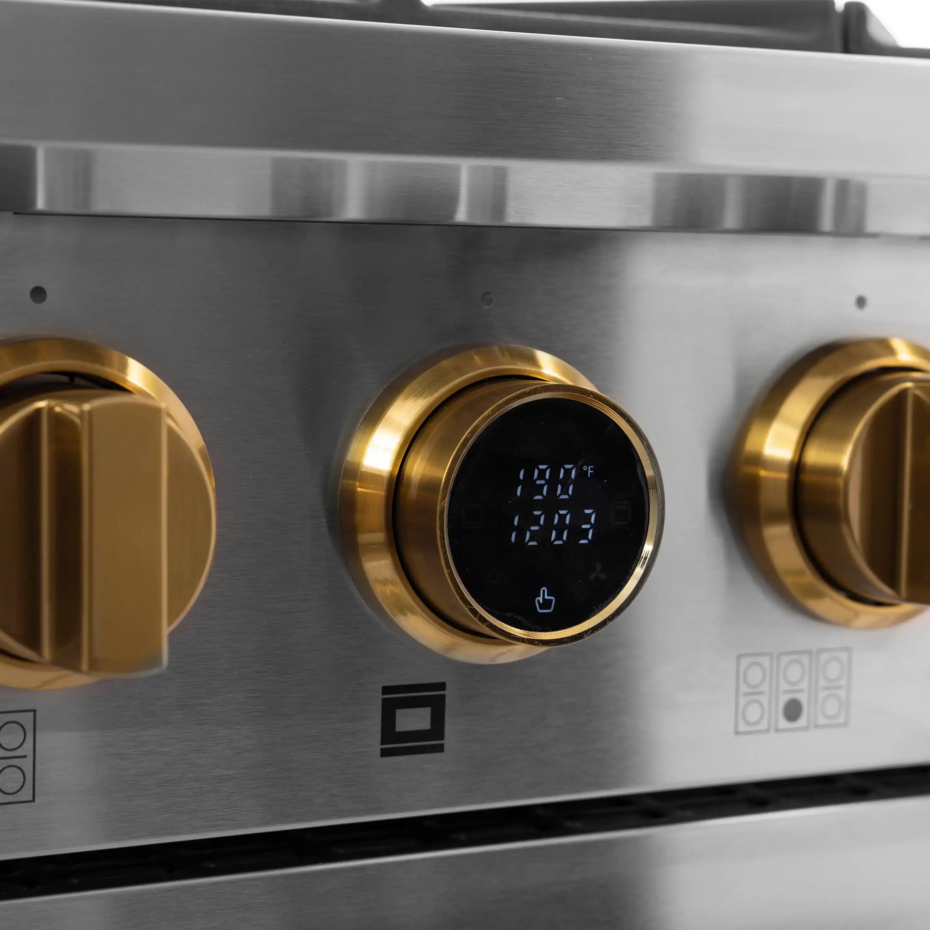 Stainless dual fuel range close-up of gold knobs and digital temperature display