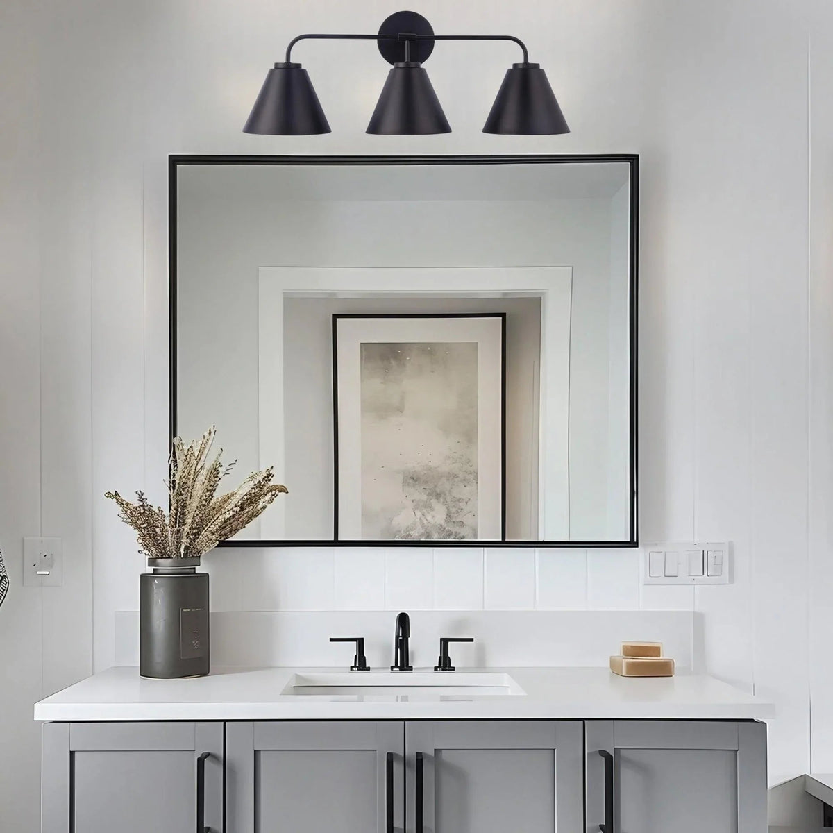 Black 3-light vanity light with three cone shades on a horizontal bar and round backplate