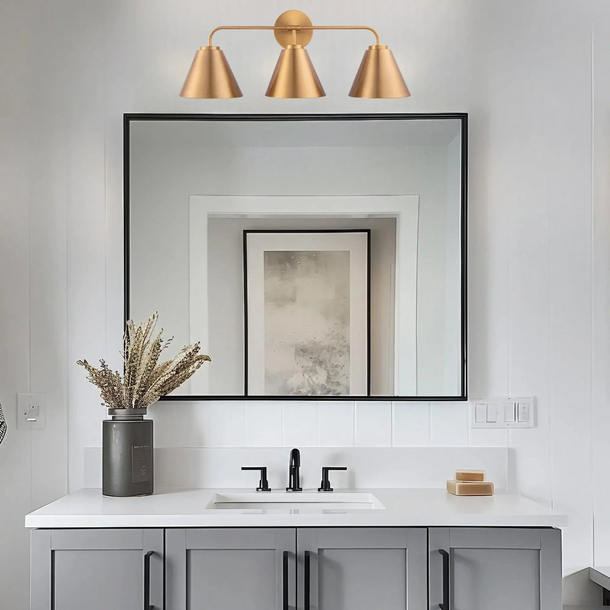 Golden 3-light vanity light with three cone shades on a horizontal bar and round backplate