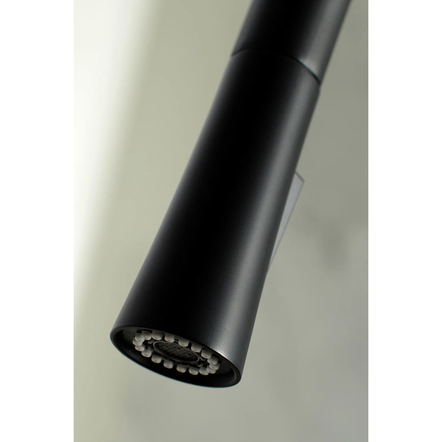 Matte black pull-down spray head underside with multi-jet nozzle holes