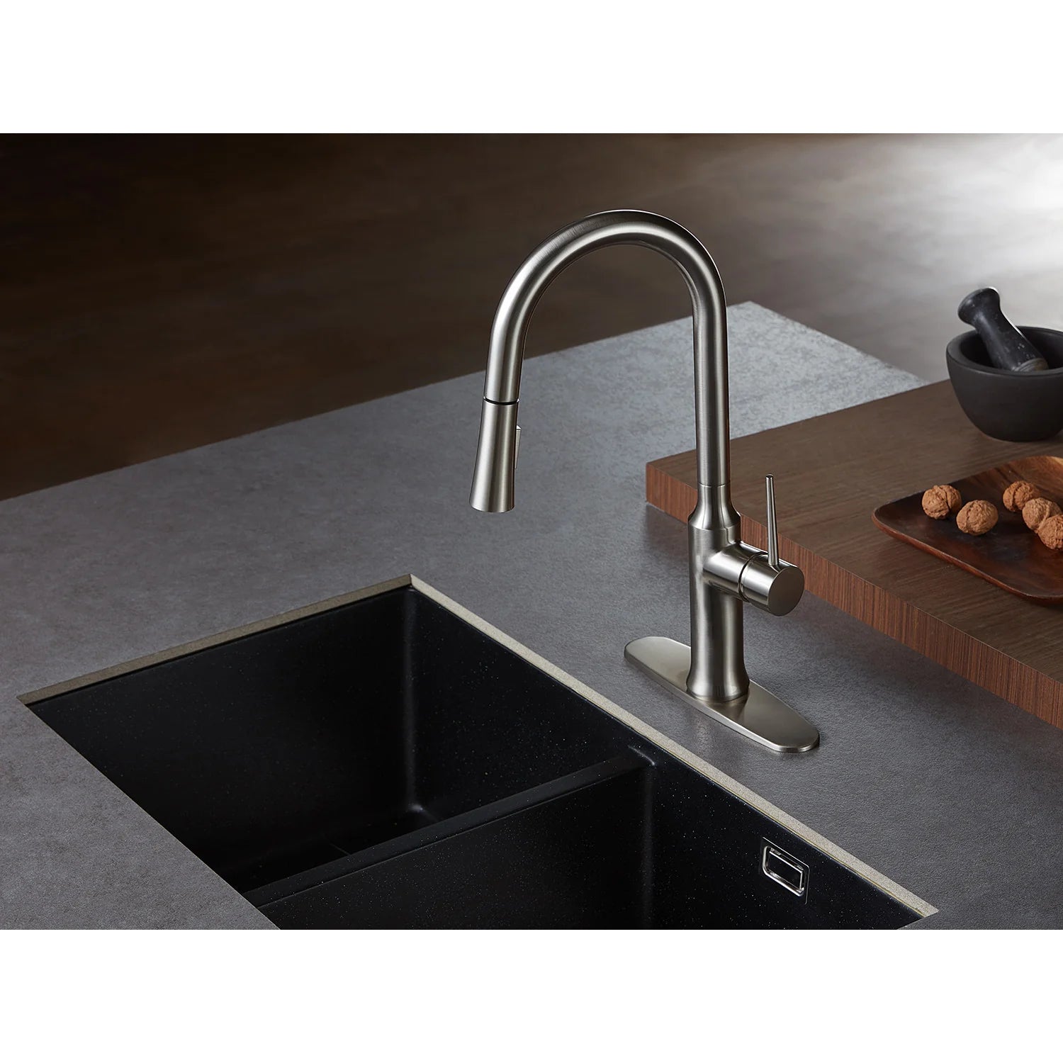 Brushed nickel pull-down kitchen faucet over a stainless sink with side sprayer