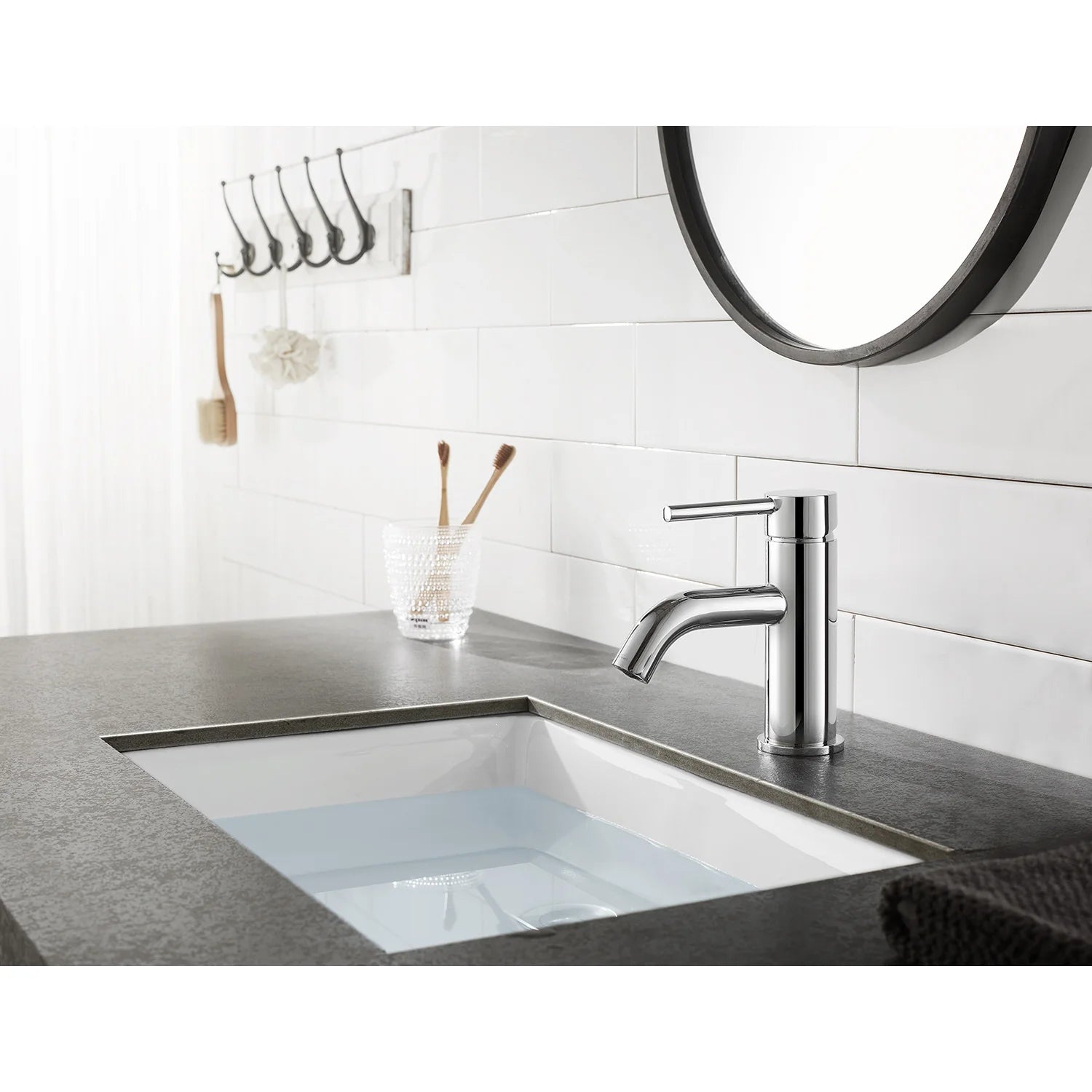 Polished chrome single-hole bathroom faucet mounted on sink counter in a kitchen-style setup.
