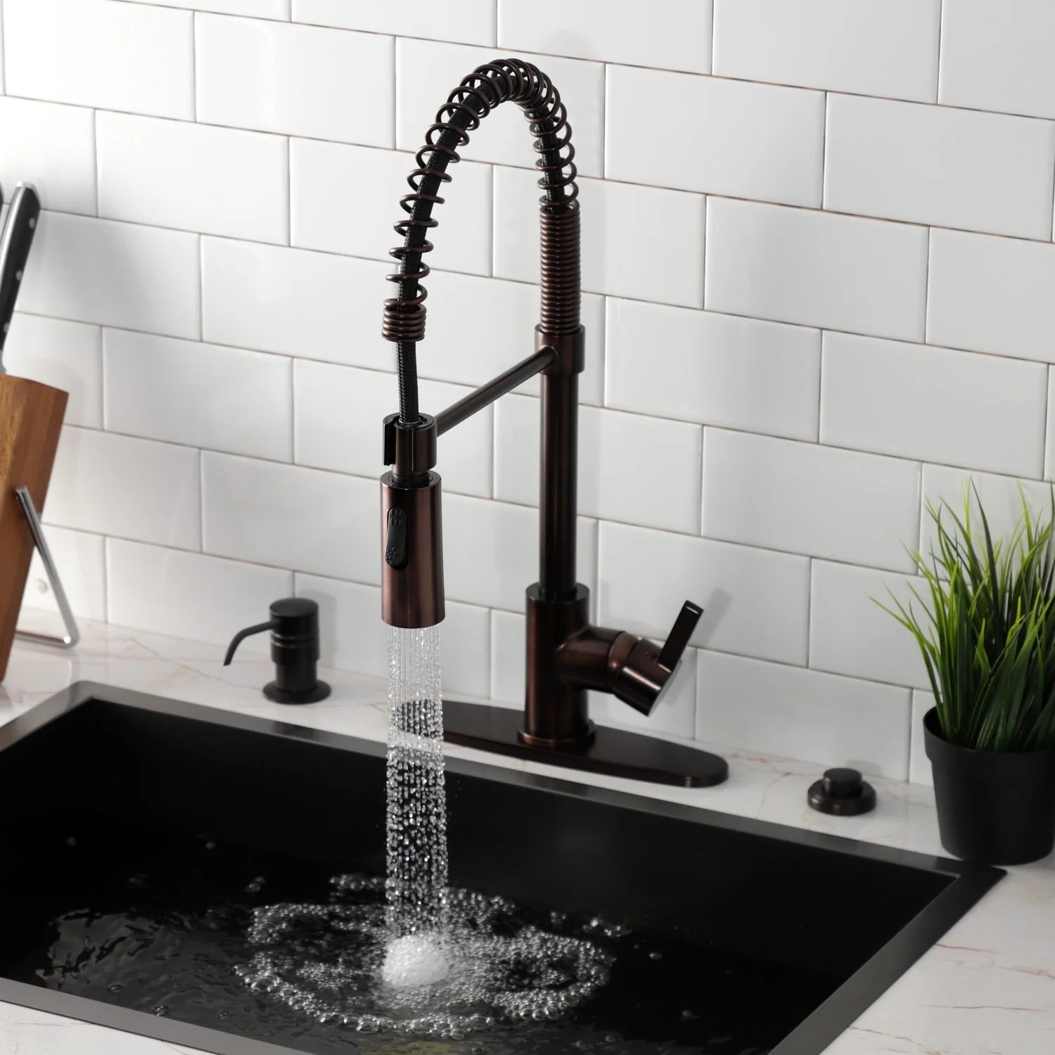 Oil-rubbed bronze deck-mount kitchen faucet over a sink with pull-down spray hose