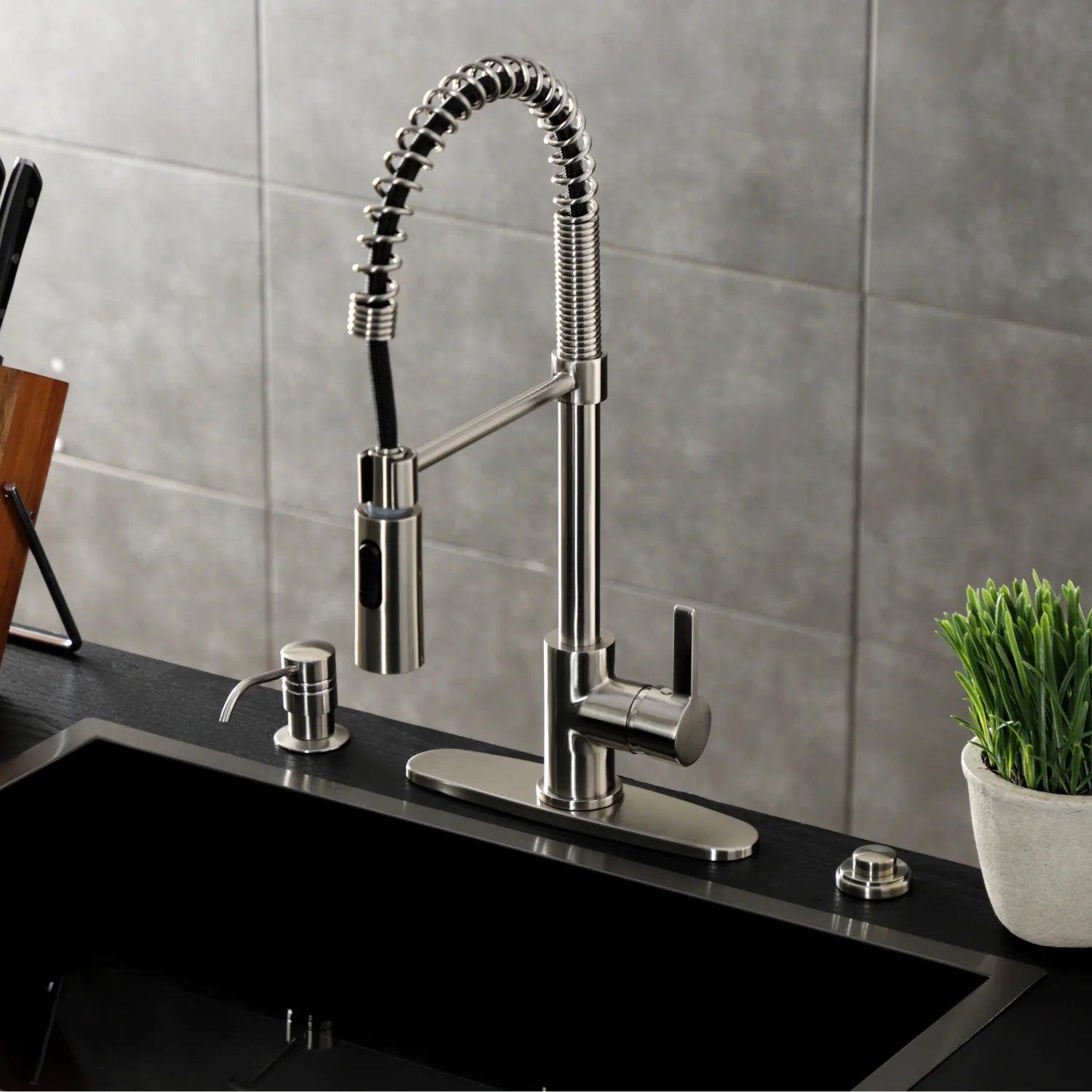 Brushed nickel deck-mount pre-rinse kitchen faucet on black countertop