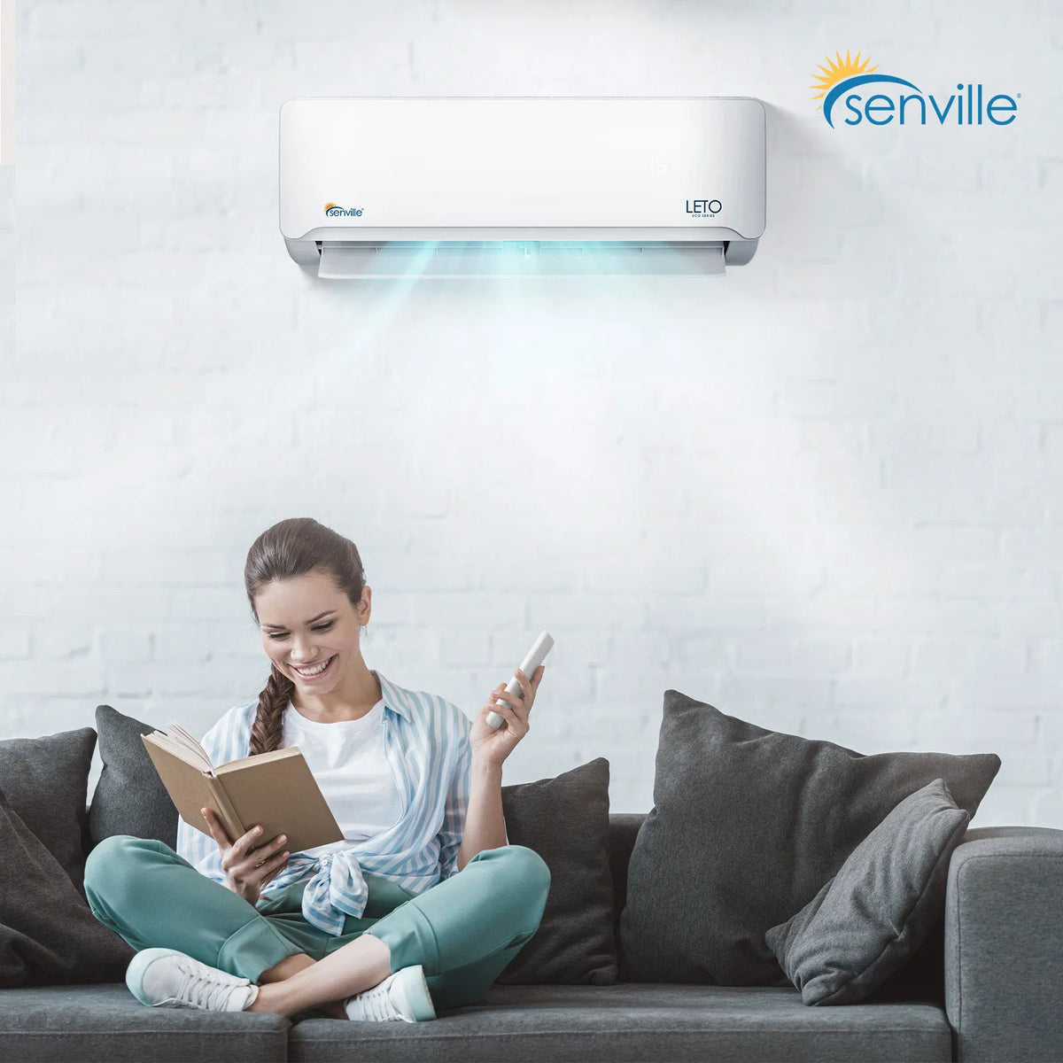 Wall-mounted mini split air handler above sofa, white LETO unit with blue airflow