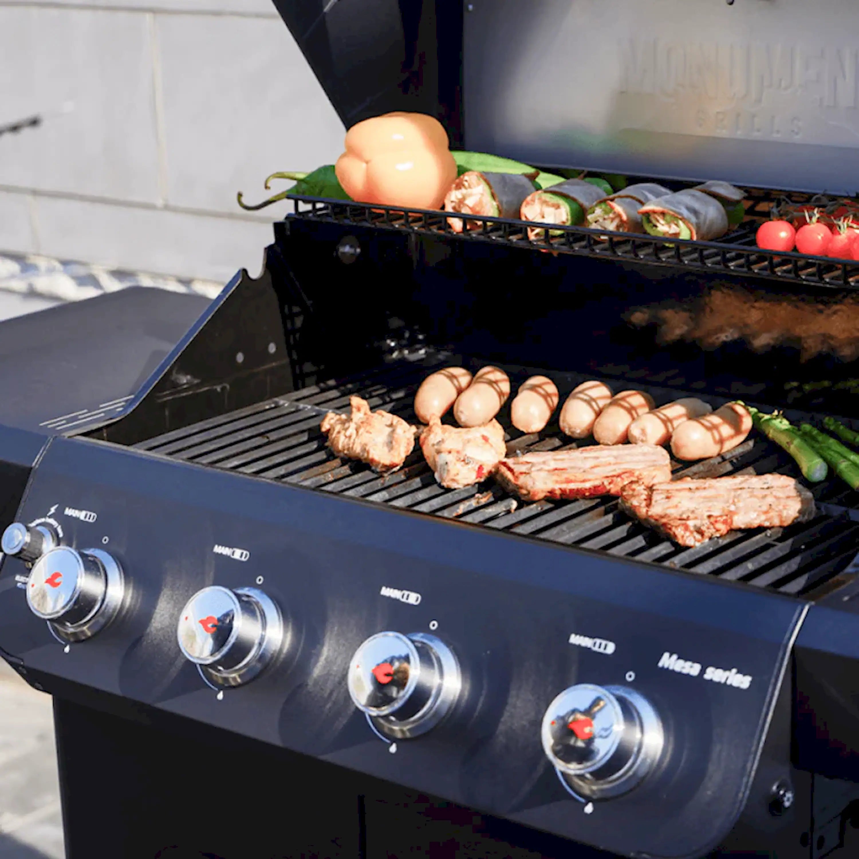 Food cooking on grill grates with eggs, vegetables, and meat in a black 4-burner grill