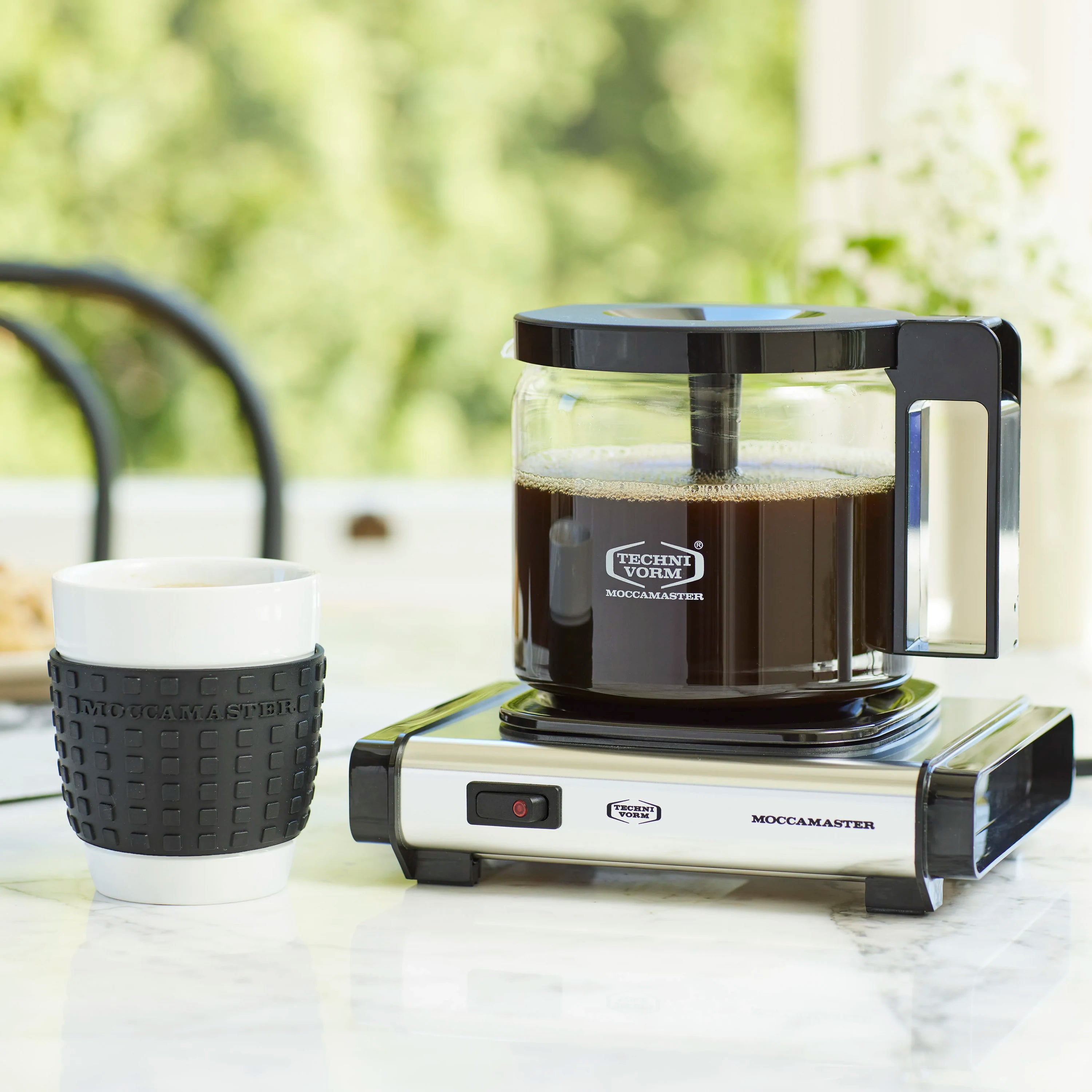 Stainless steel hotplate base with black round heating plate, coffee pot on top