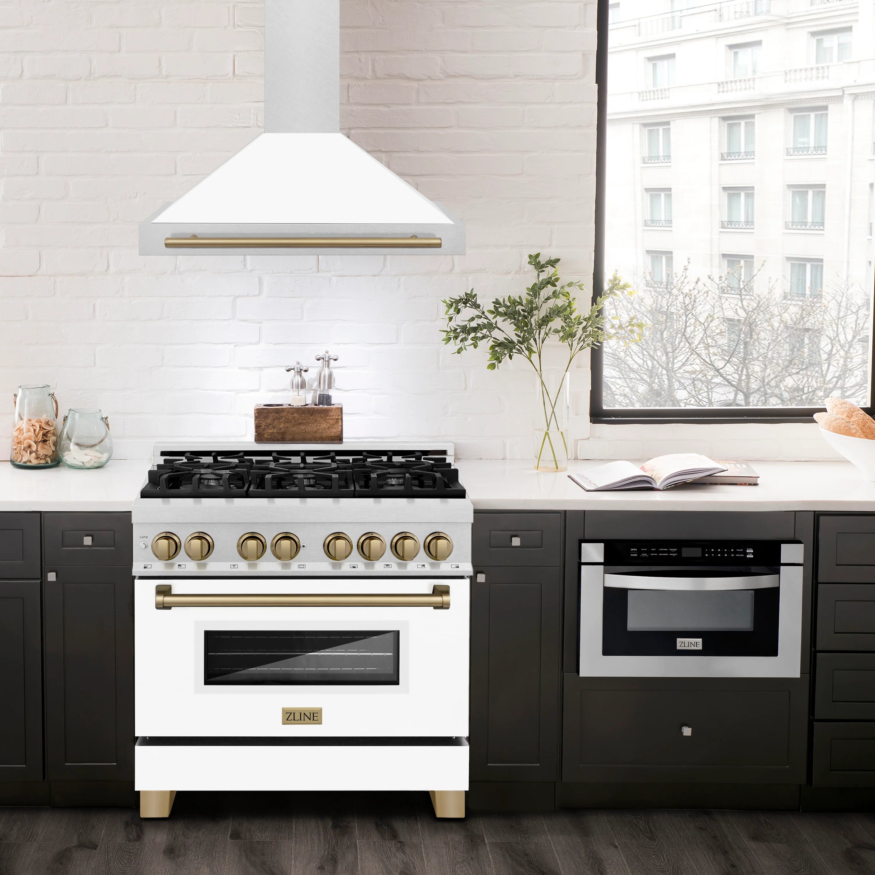 White wall-mounted range hood above a cooktop, satin stainless with champagne bronze bar handle