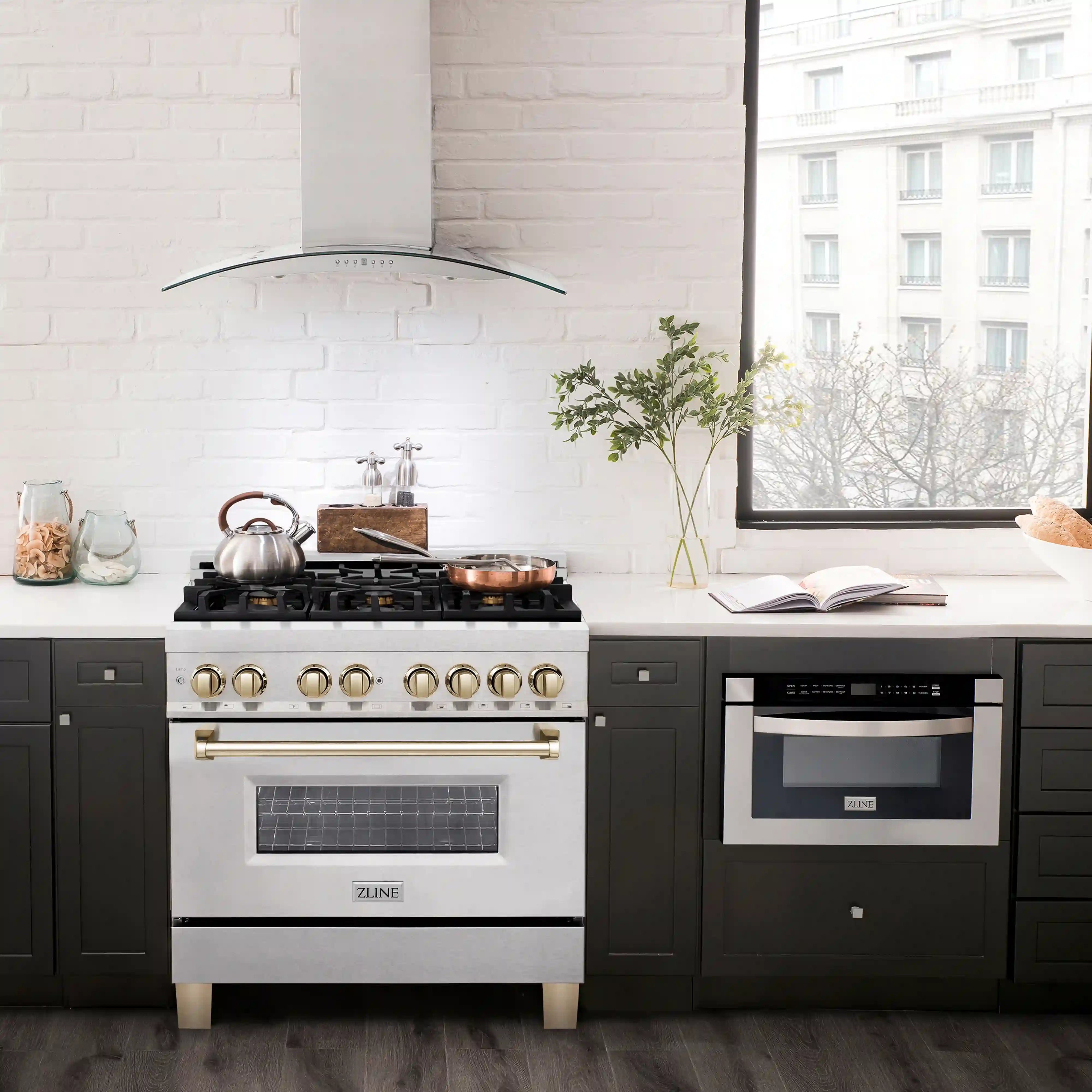 Dual fuel range with black cooktop, gold knobs, and oven door on satin stainless steel