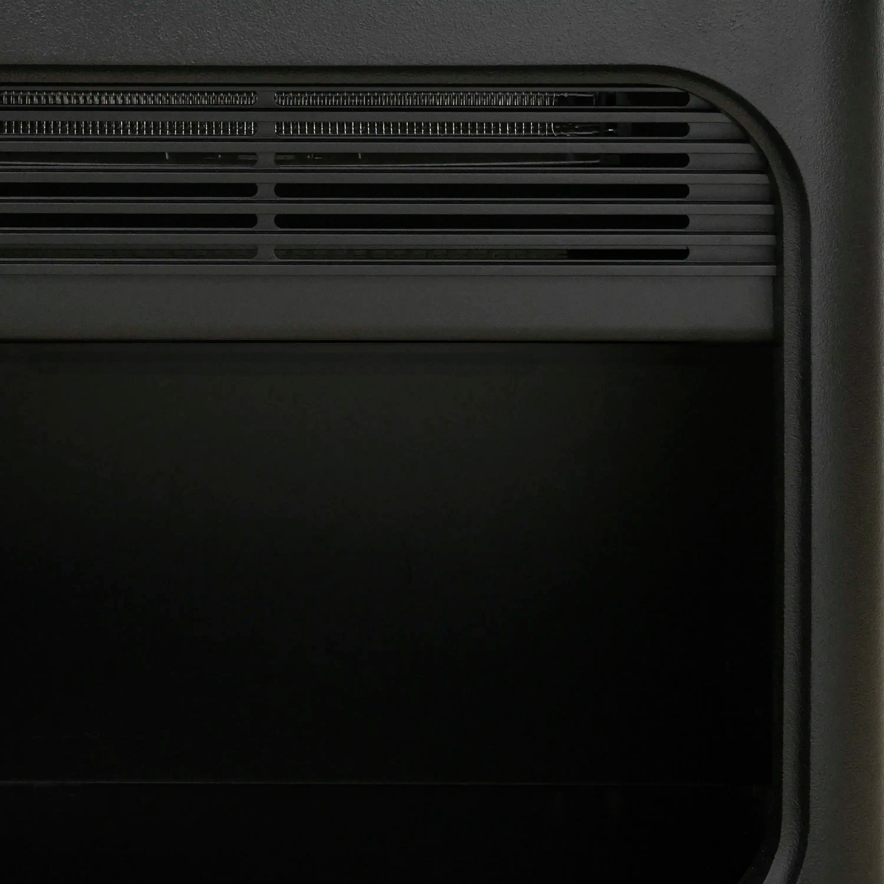 Black water vapor fireplace vent grille with rounded corner trim panel.