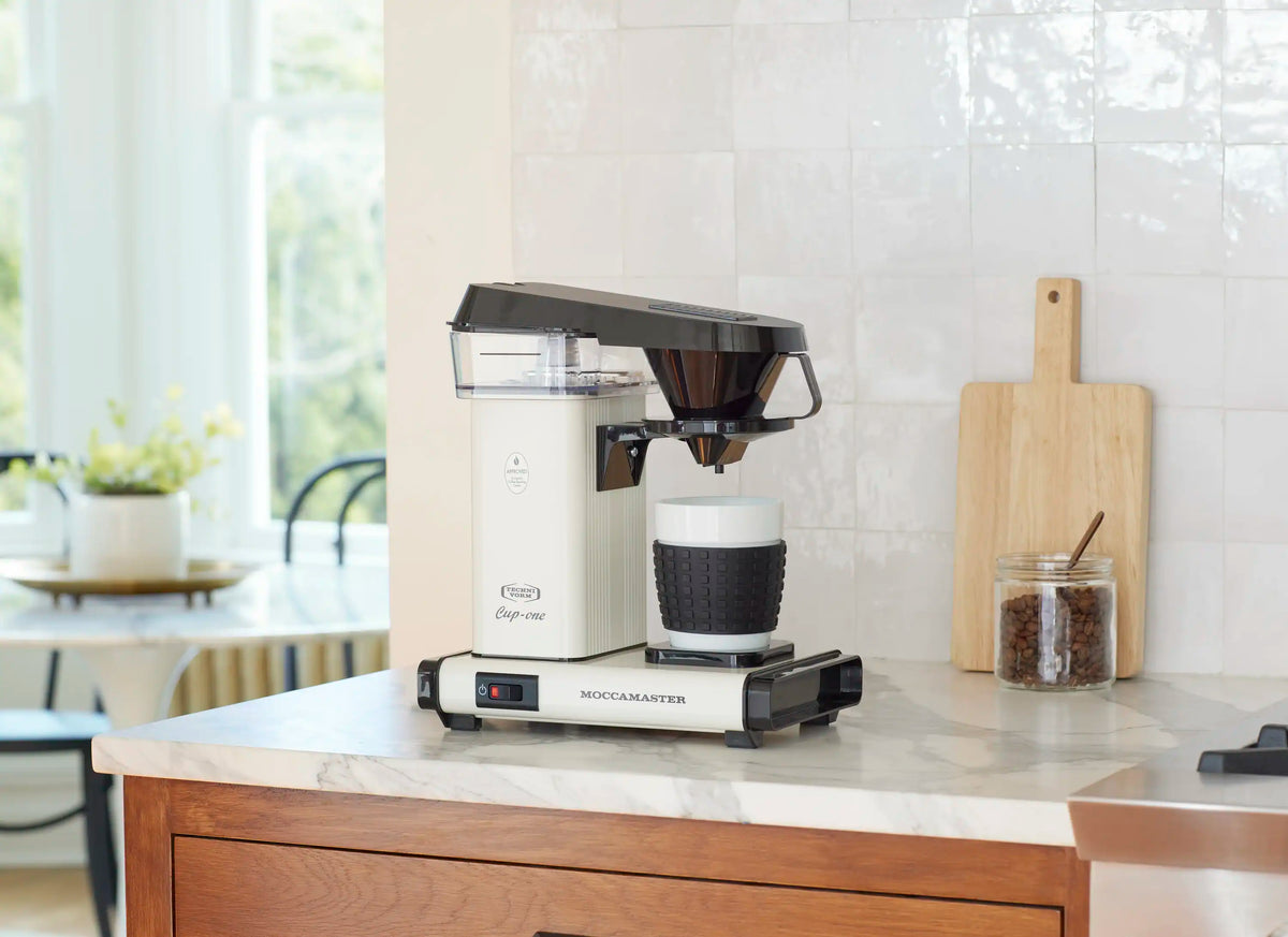 Off-white Moccamaster Cup-One single coffee maker on countertop with black filter and cup