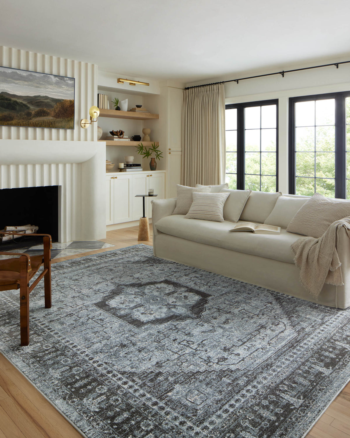 Blue-gray and charcoal traditional area rug with central medallion and border, low pile.