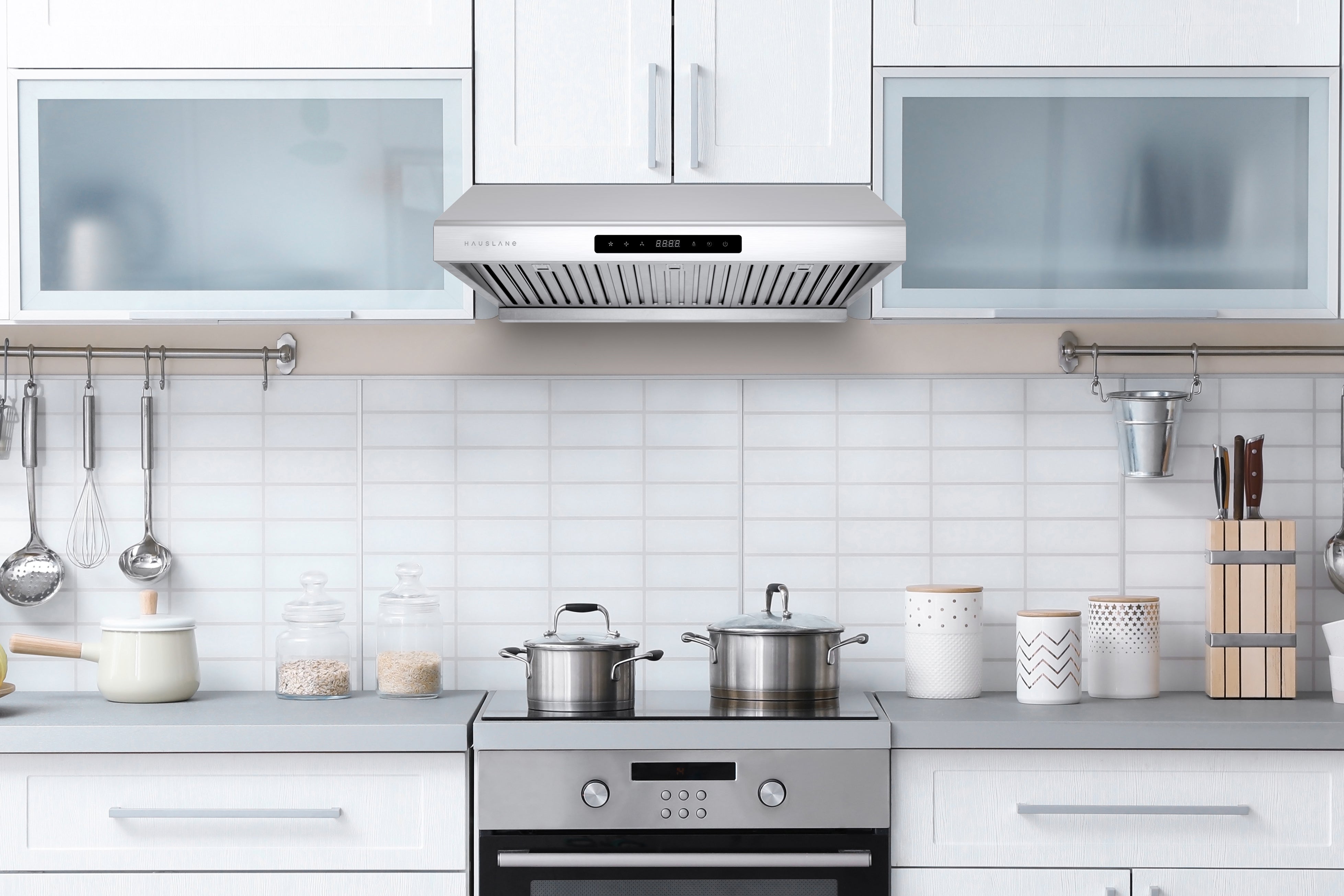 Stainless steel under-cabinet range hood installed above a cooktop