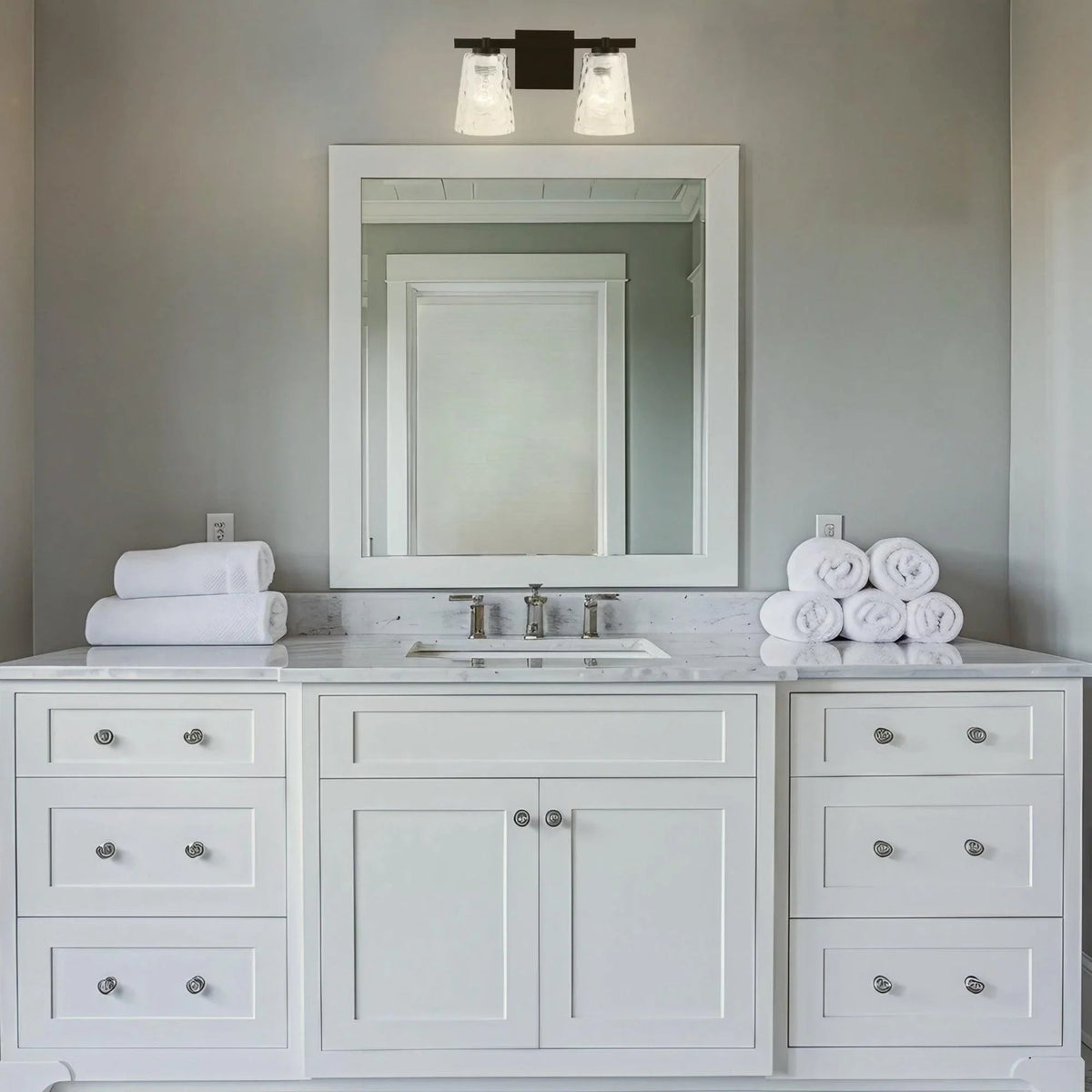 2-light vanity light with two clear glass shades and black mounting bracket.