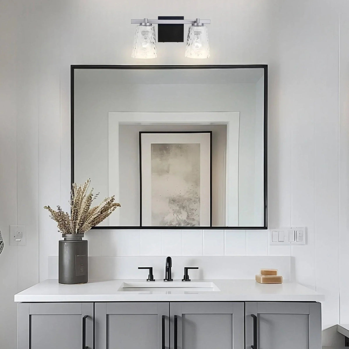 2-light vanity light with clear glass shades and black rectangular frame.