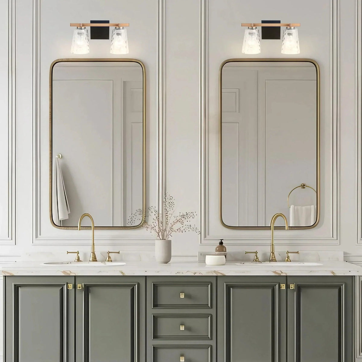 2-light vanity light with clear glass shades and gold-toned arched backplates.