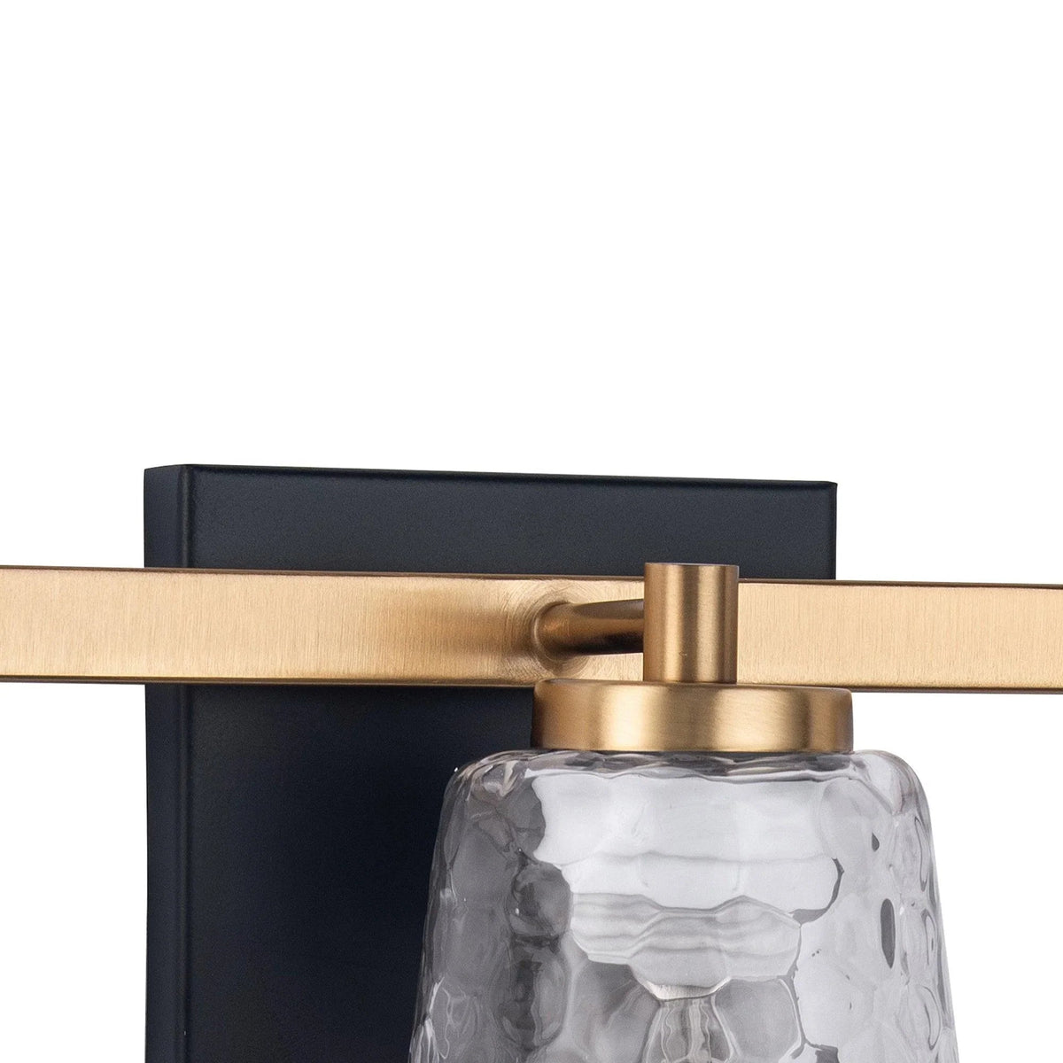 3-light vanity light close-up with gold-toned mount and clear textured glass shade.