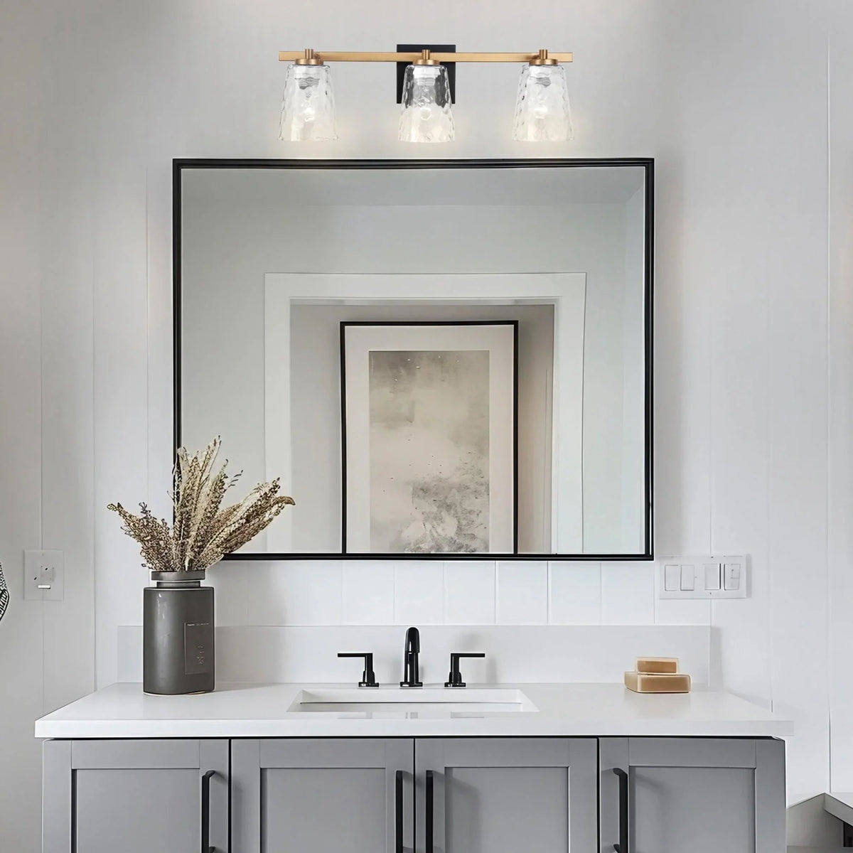 3-light vanity light with matte black bar and clear glass shades.