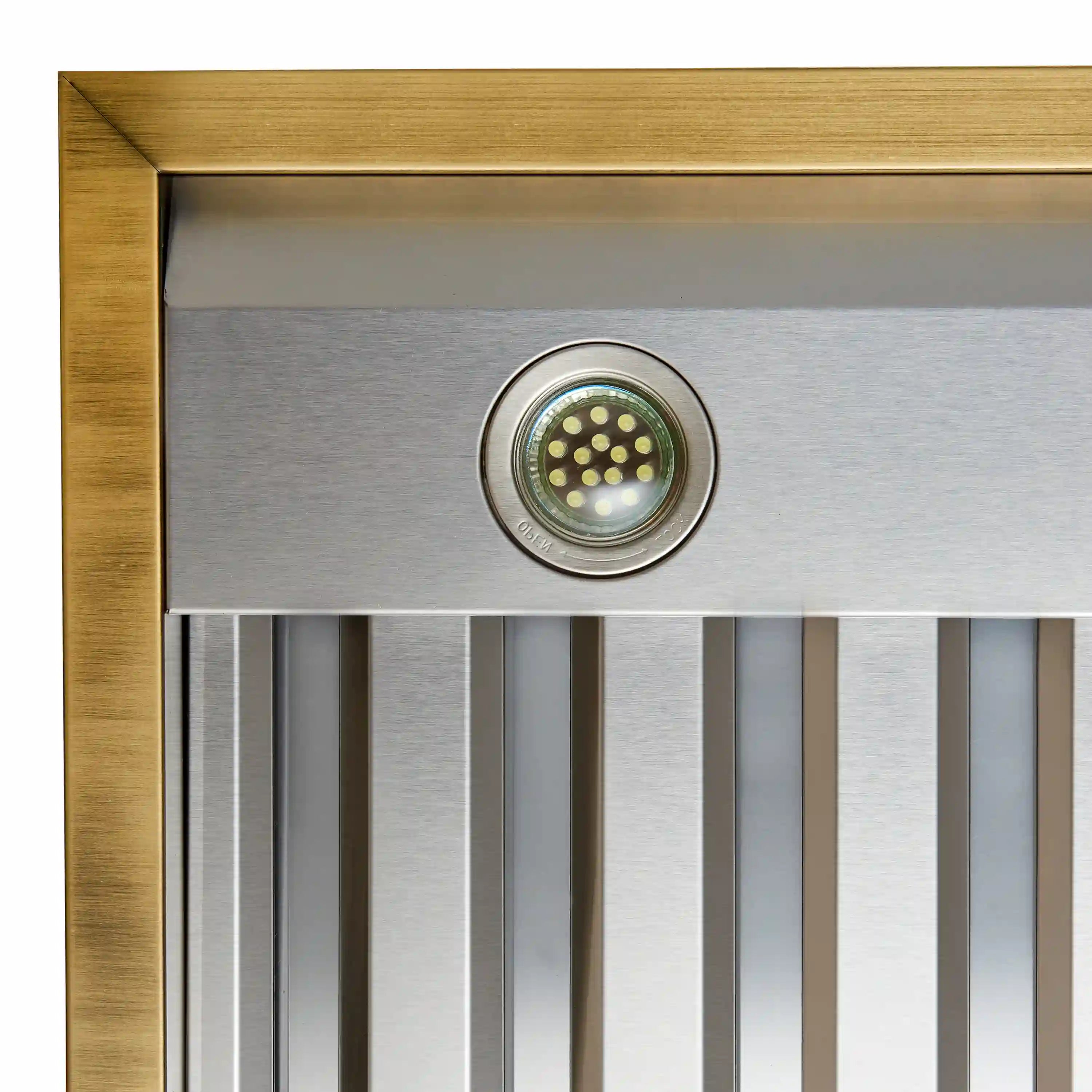 Range hood vent panel with circular fan grille and antique brass frame