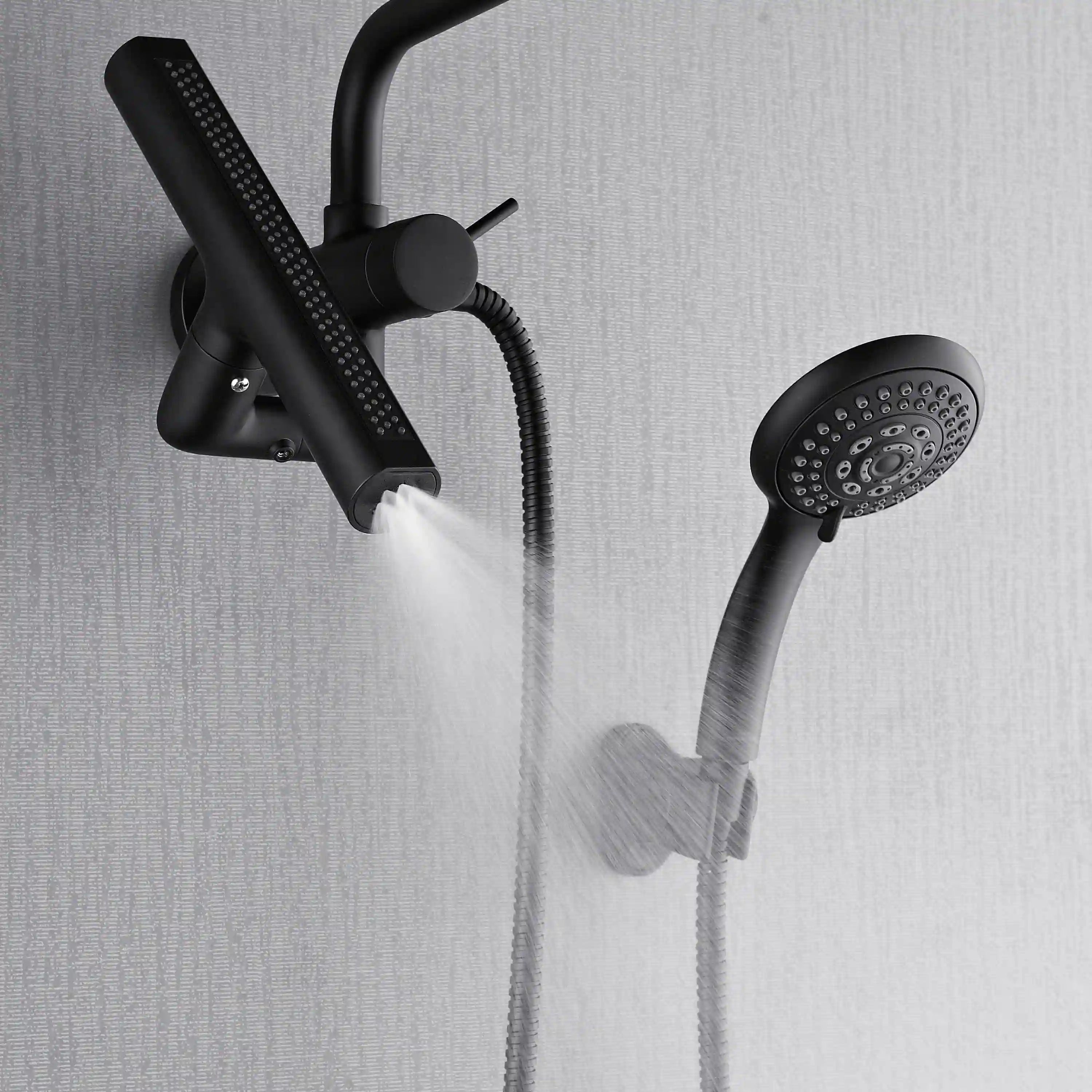 Matte black shower system with overhead rain head and handheld sprayer spraying water