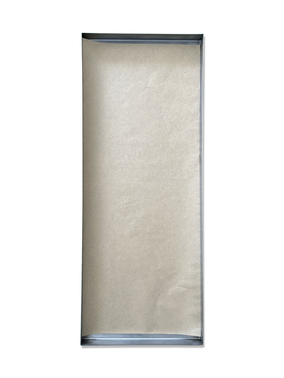 Light beige parchment paper sheet lined in a metal baking tray