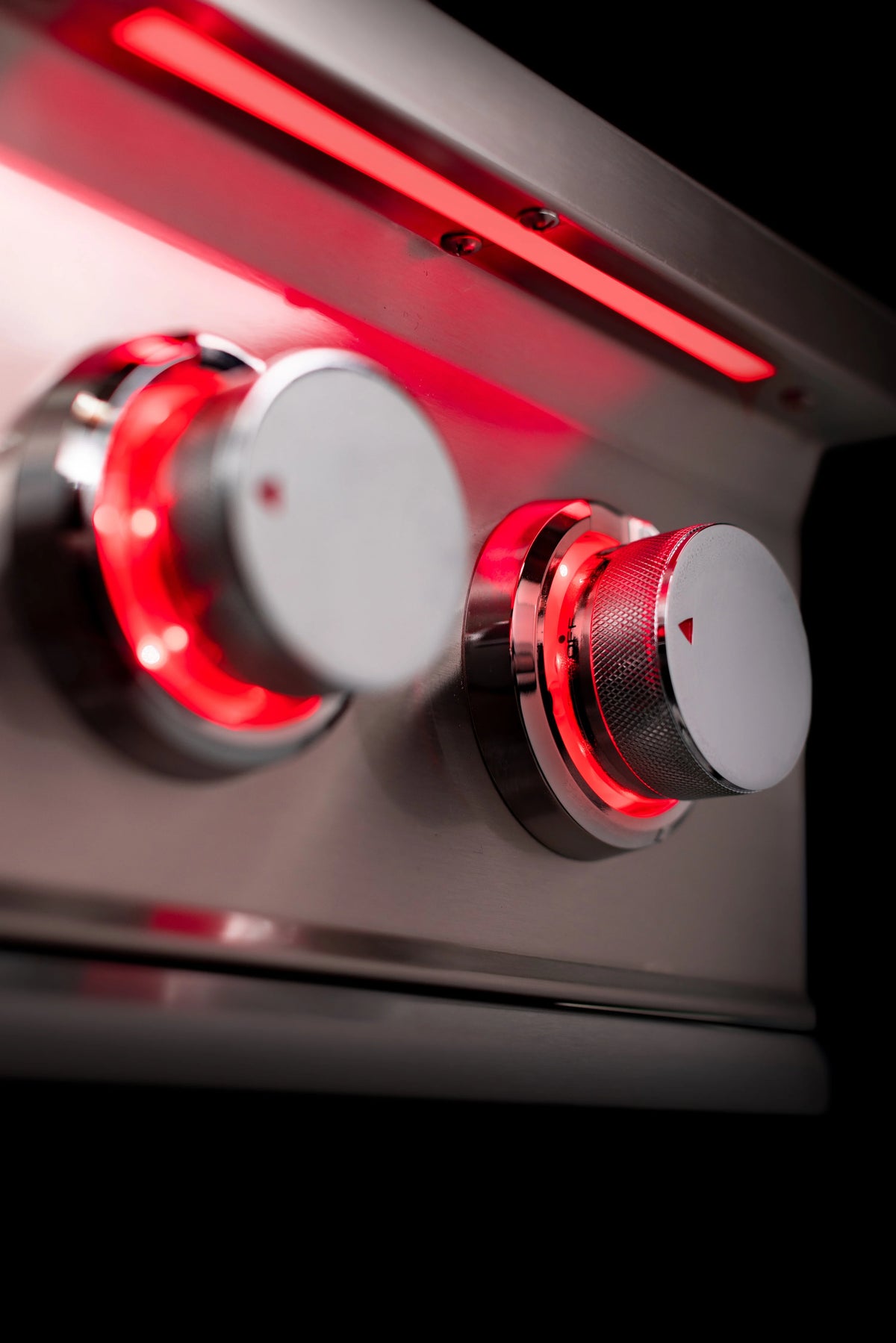 Double natural gas side burner controls with two round knobs and glowing burner area