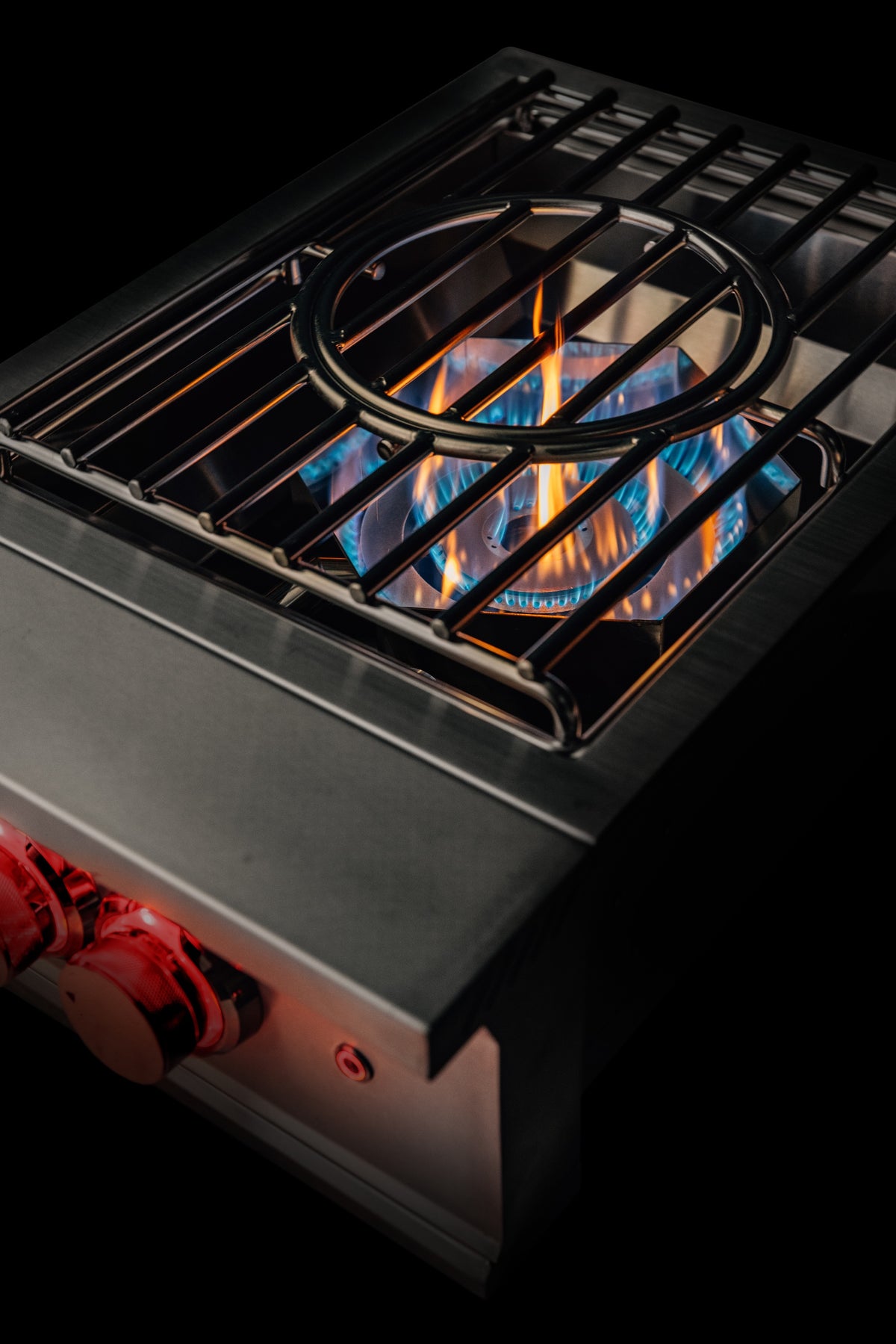 Stainless steel natural gas burner with cast grates and visible blue flames
