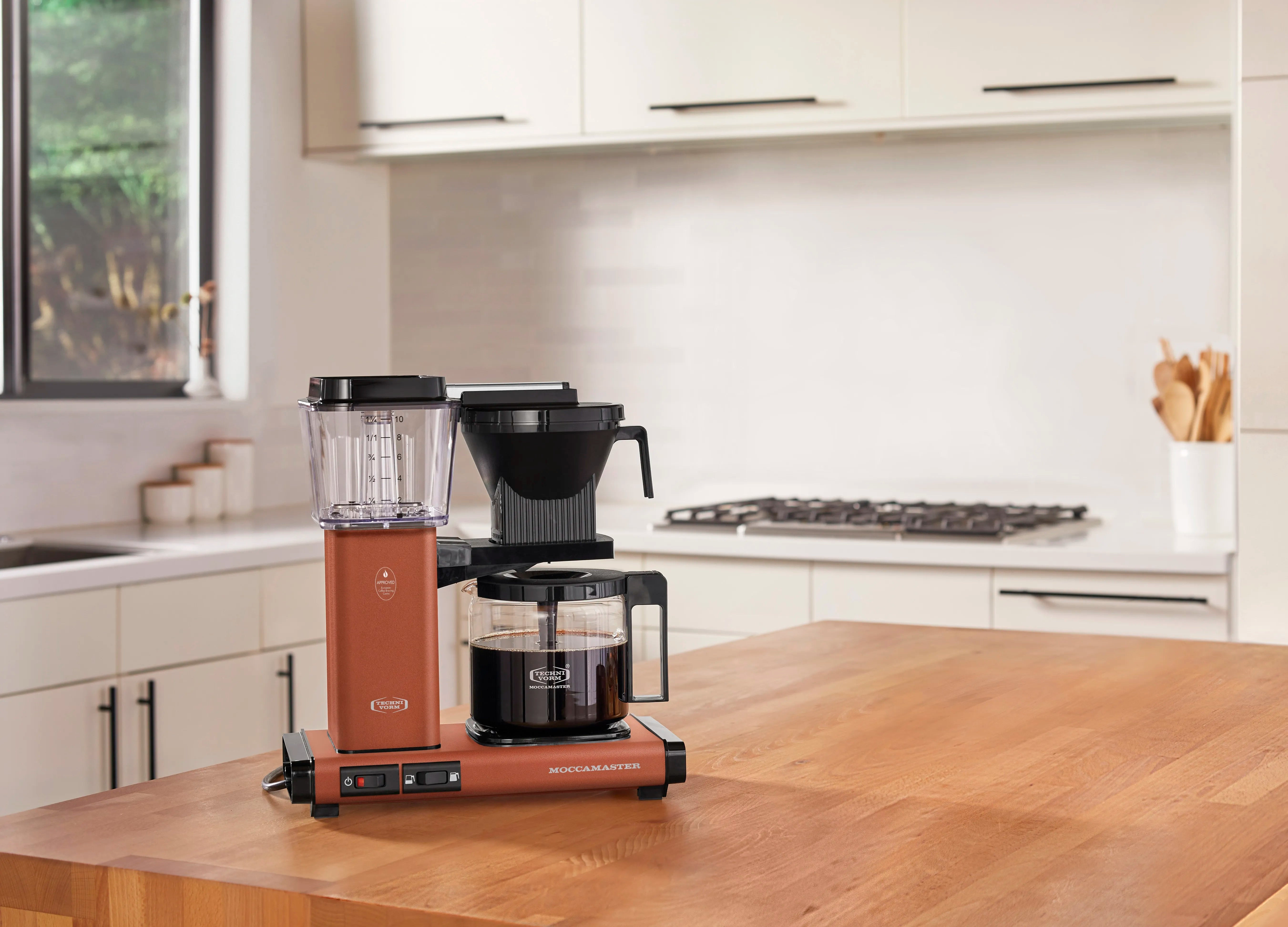 Terracotta countertop drip coffee maker with glass carafe and black brew cone