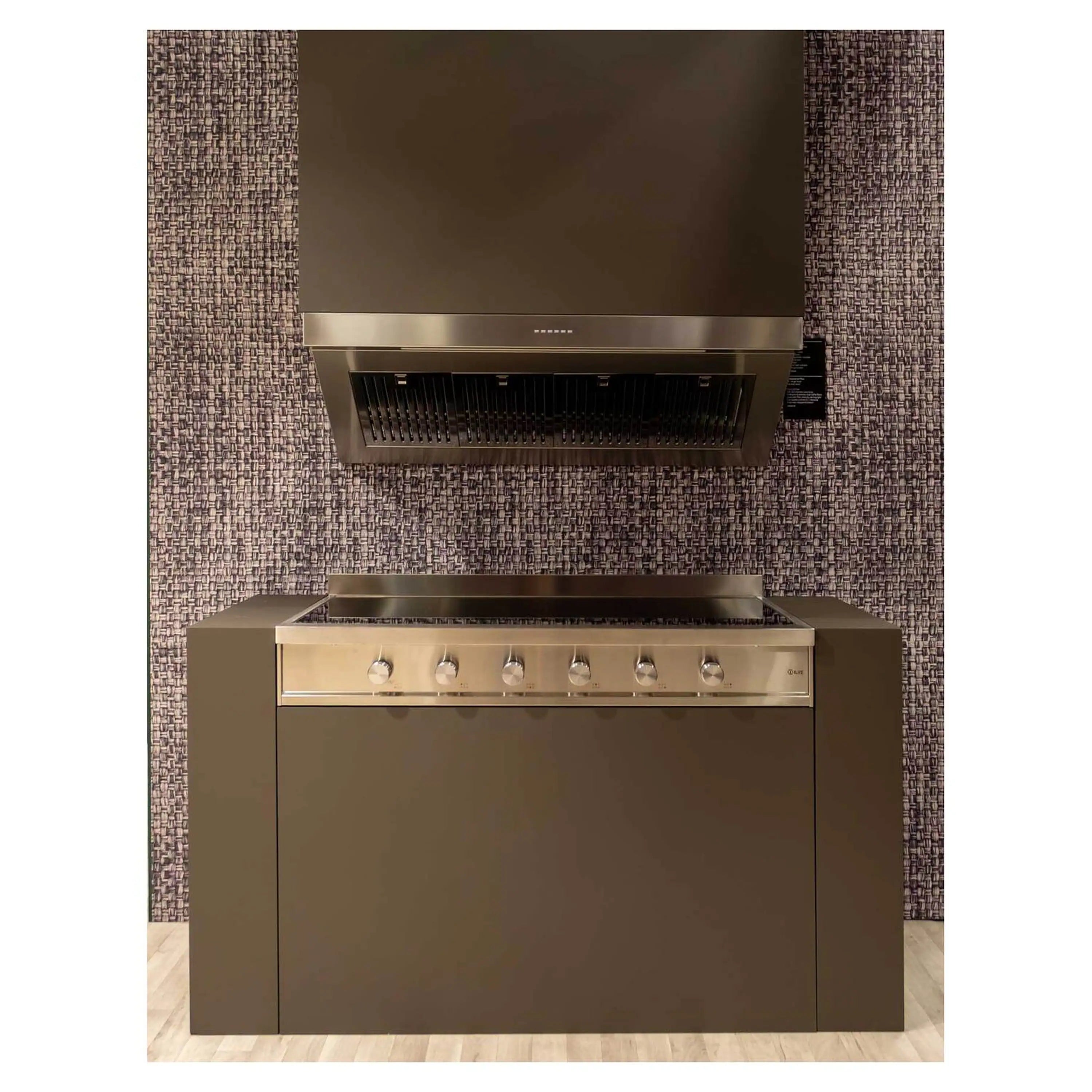 Stainless steel induction cooktop with black glass surface, control knobs, and matching hood
