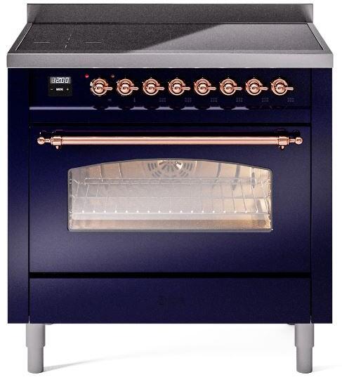 Freestanding induction range front with copper control knobs and glass oven window