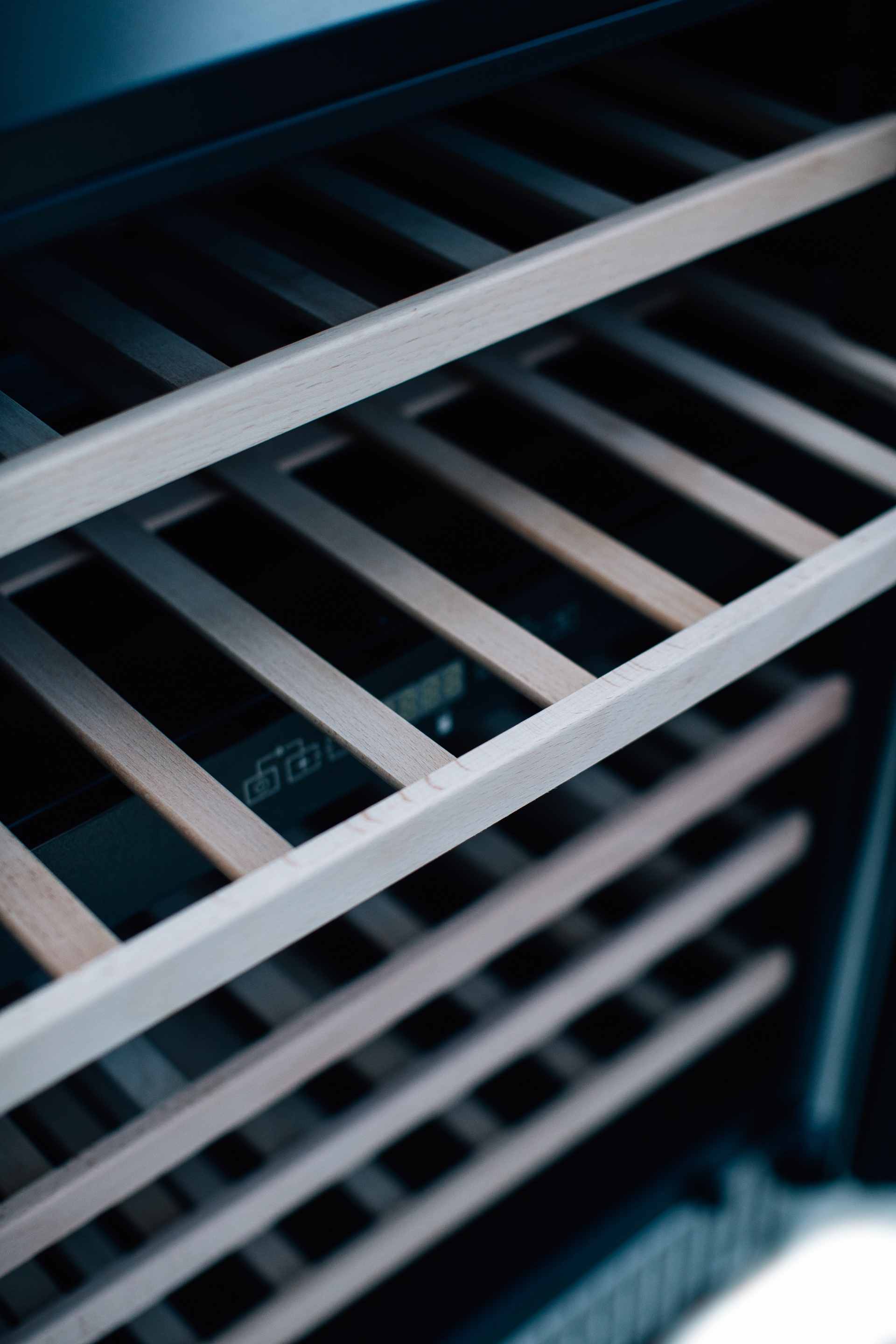 Wine cooler interior rack with sliding metal rails and bottle slots