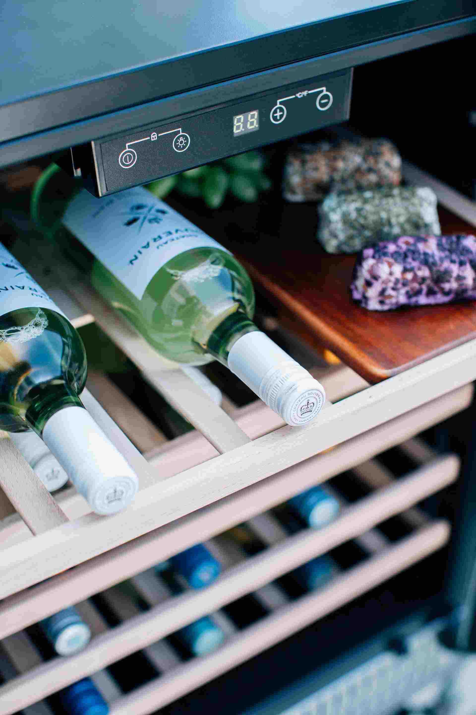 Wine cooler control panel above bottle shelves with digital temperature display