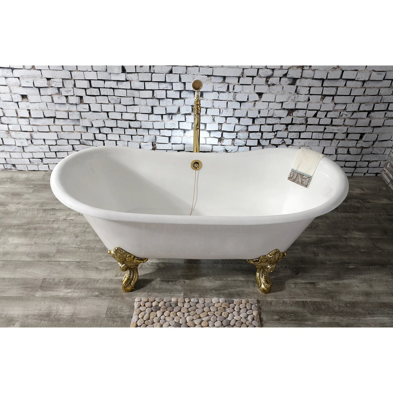 White oval freestanding clawfoot tub with polished brass feet and rear-mounted drain
