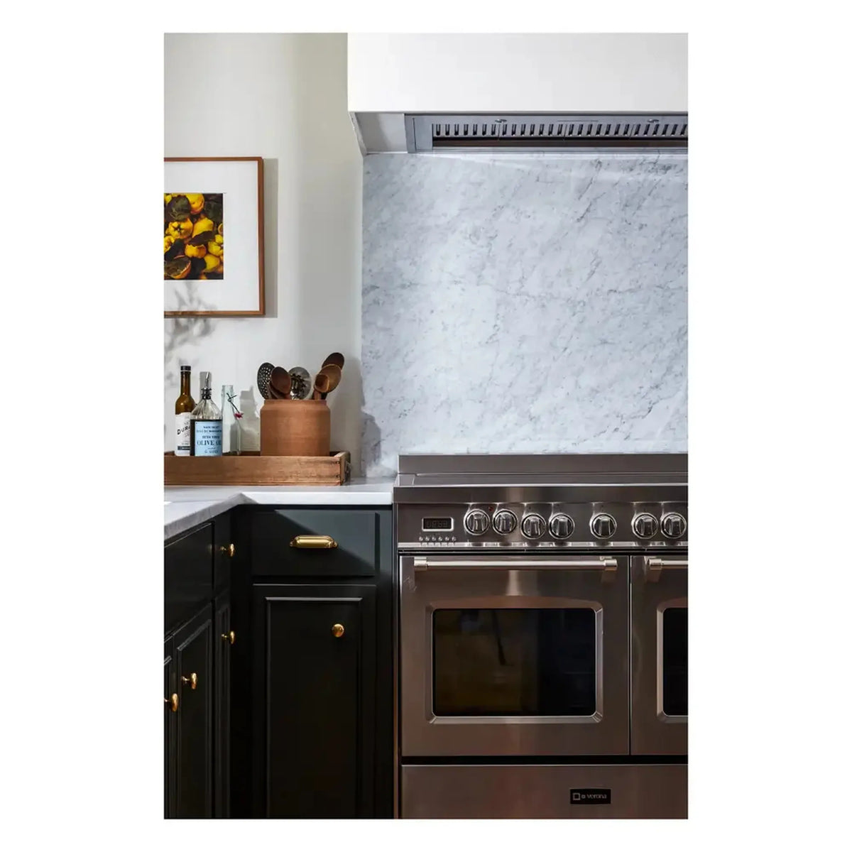 Stainless electric range with double ovens under range hood, close corner view