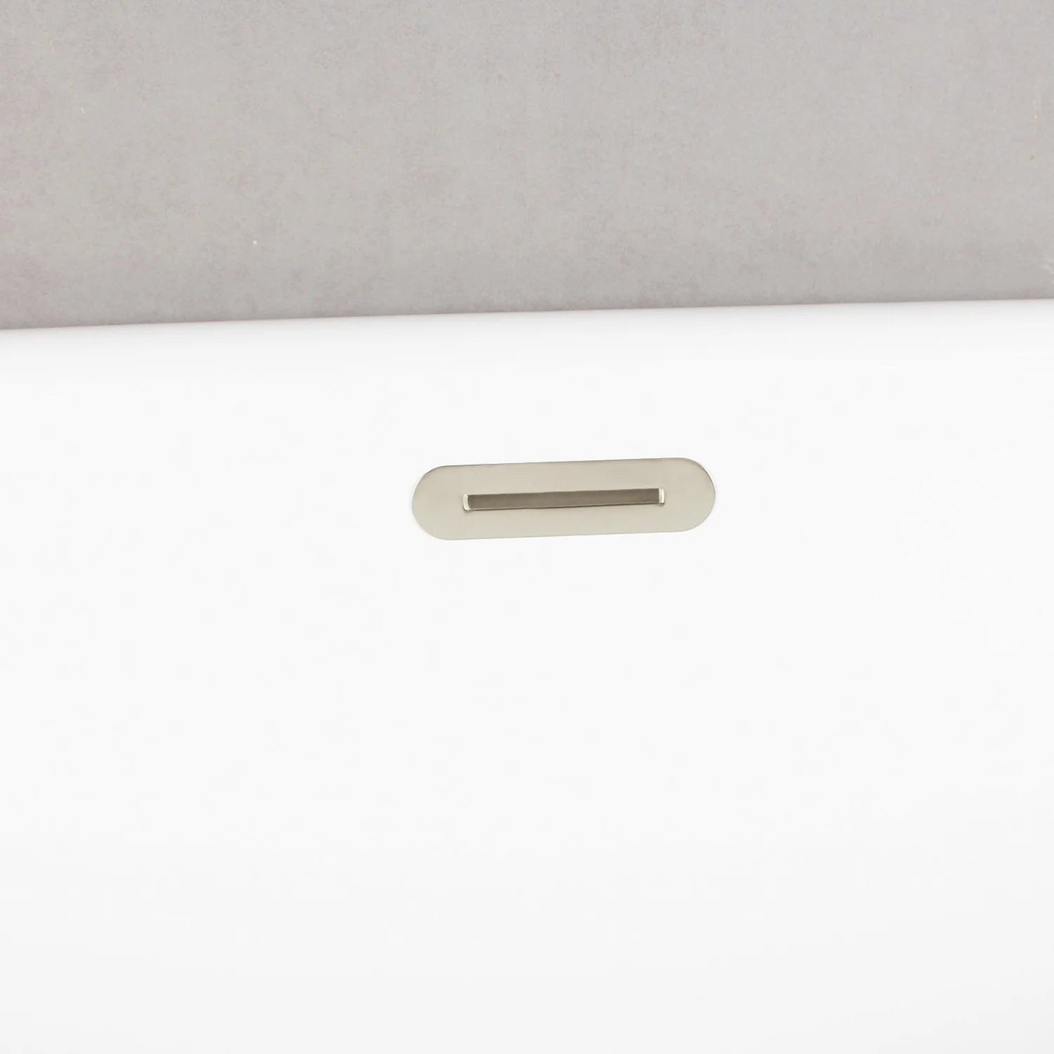 Glossy white tub overflow opening with polished nickel trim