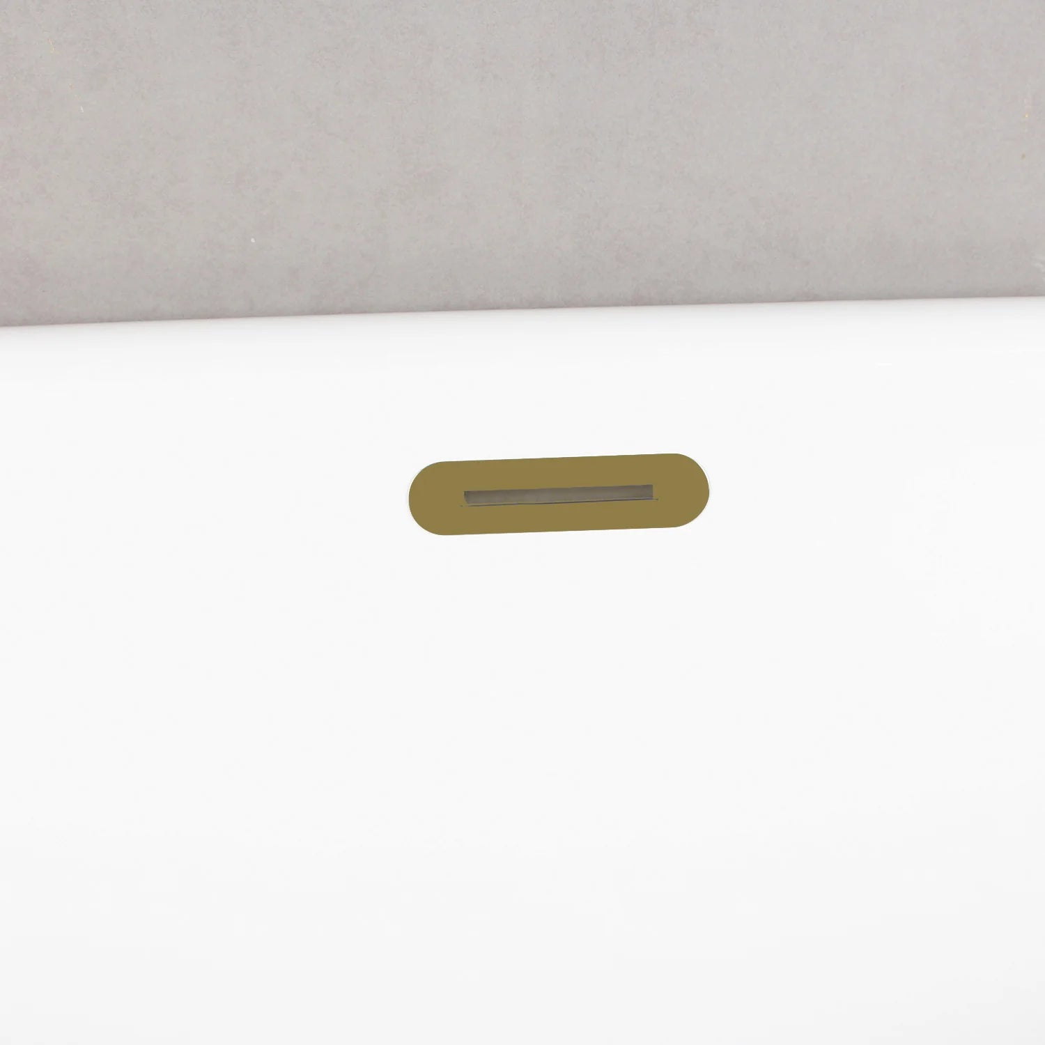 Brushed brass overflow slot on glossy white oval acrylic tub