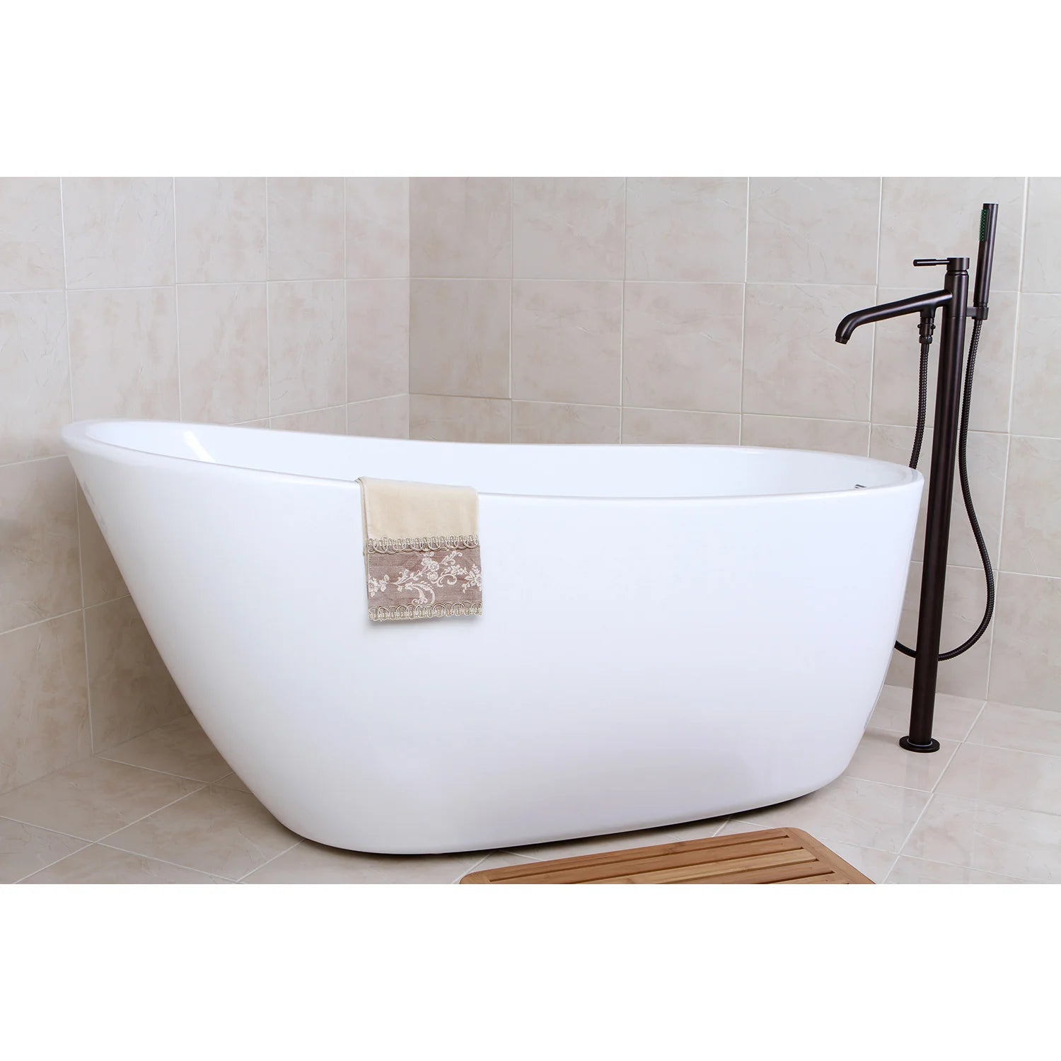 Glossy white oval freestanding acrylic bathtub with chrome faucet and towel
