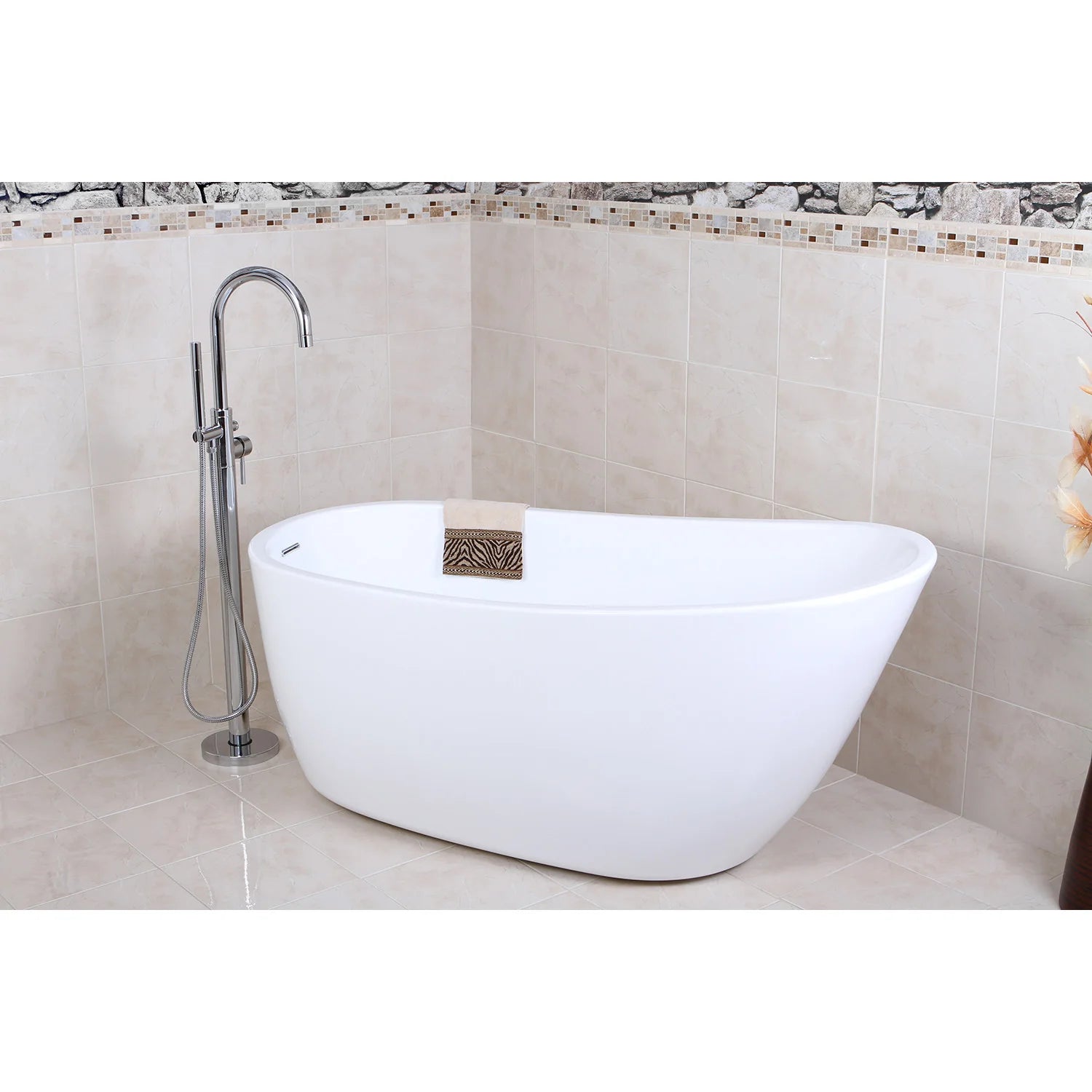 Glossy white oval freestanding acrylic bathtub beside wall tile, faucet visible