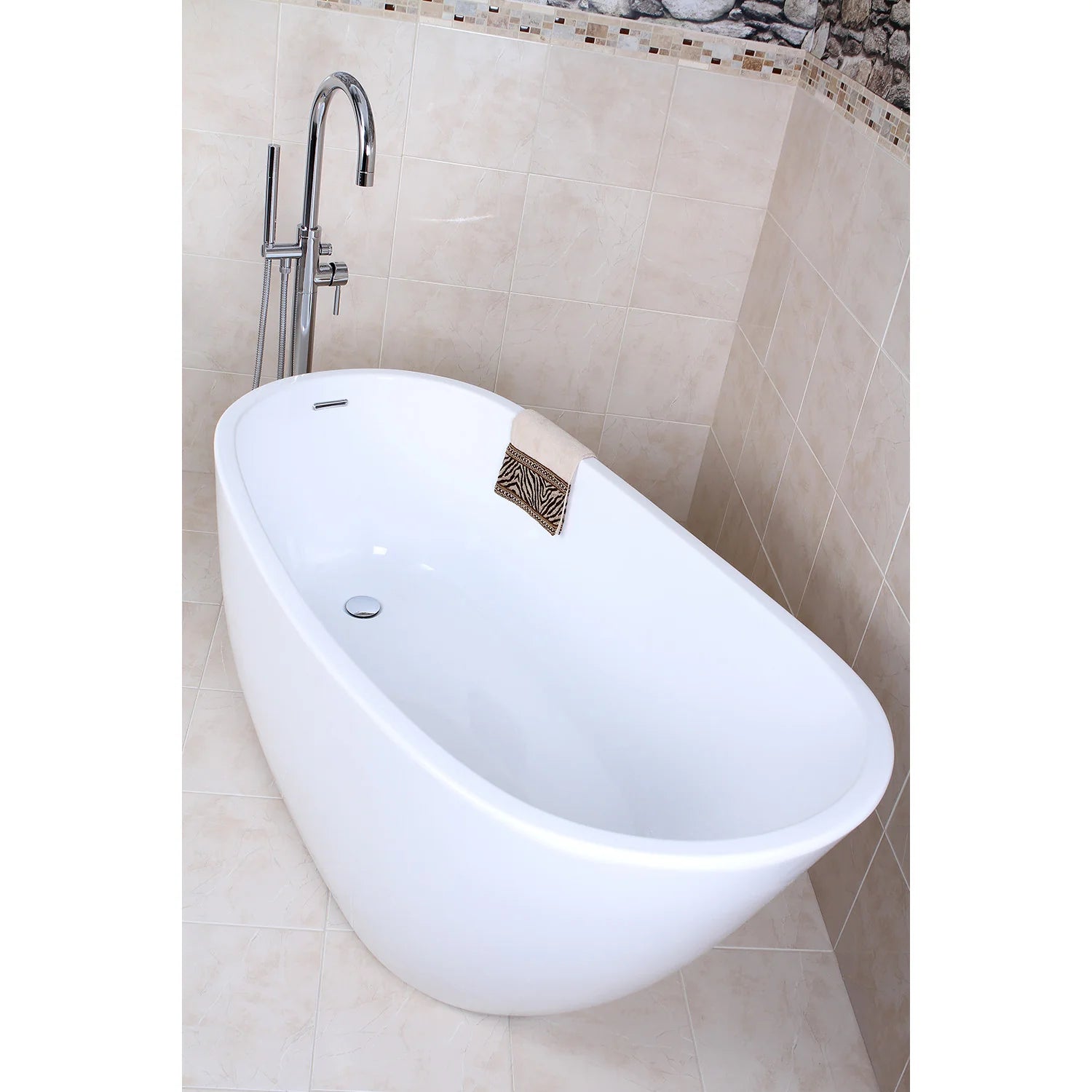 Glossy white oval freestanding acrylic bathtub with chrome faucet and drain area