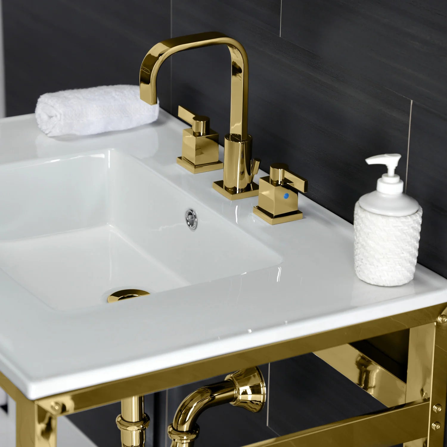 White ceramic sink top with polished brass faucet and drain, with soap dispenser