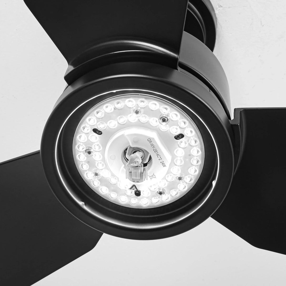 Black ceiling fan with LED light fixture, close-up of glowing circular light