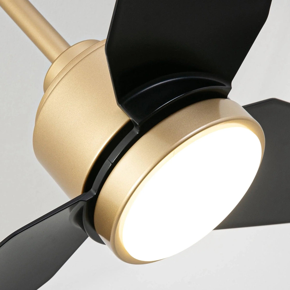Golden ceiling fan light with black blades and brass-toned housing