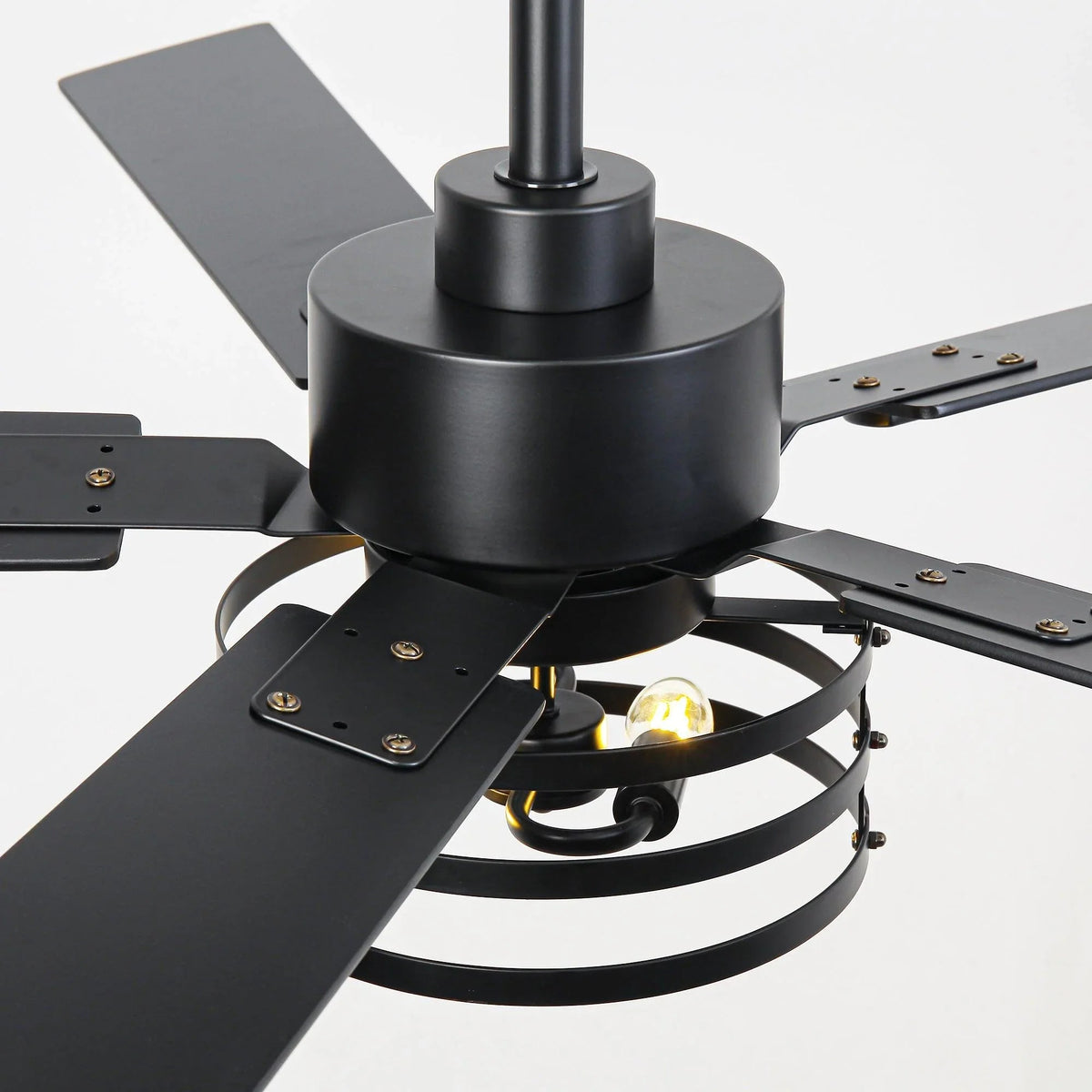 Close-up of black ceiling fan motor housing with blade arms and bulb sockets